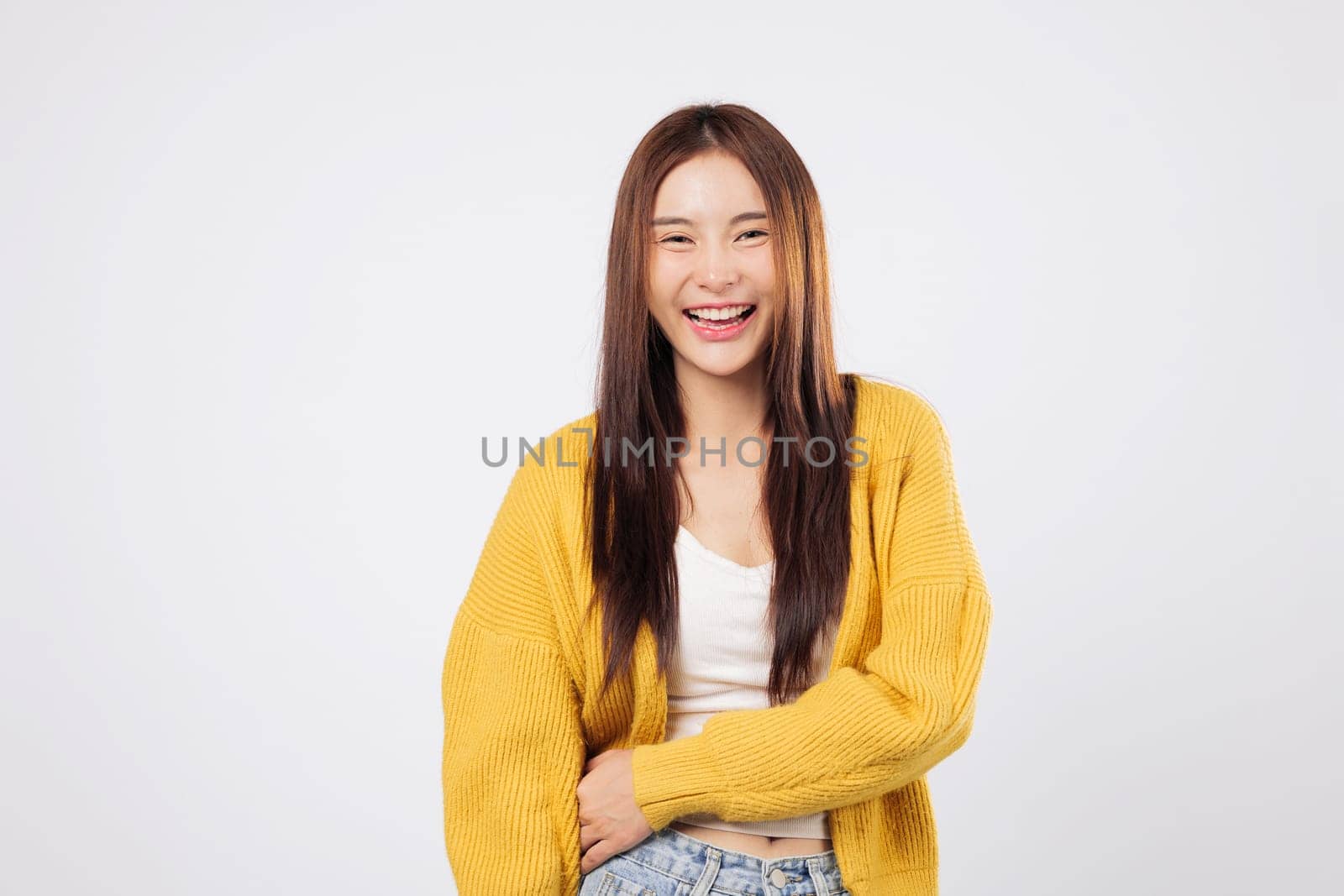 Laugh from the heart laugh with peace as a confident Asian woman smiles enjoying a lighthearted and fun lifestyle moment with natural expression isolated white background. World Laughter Day
