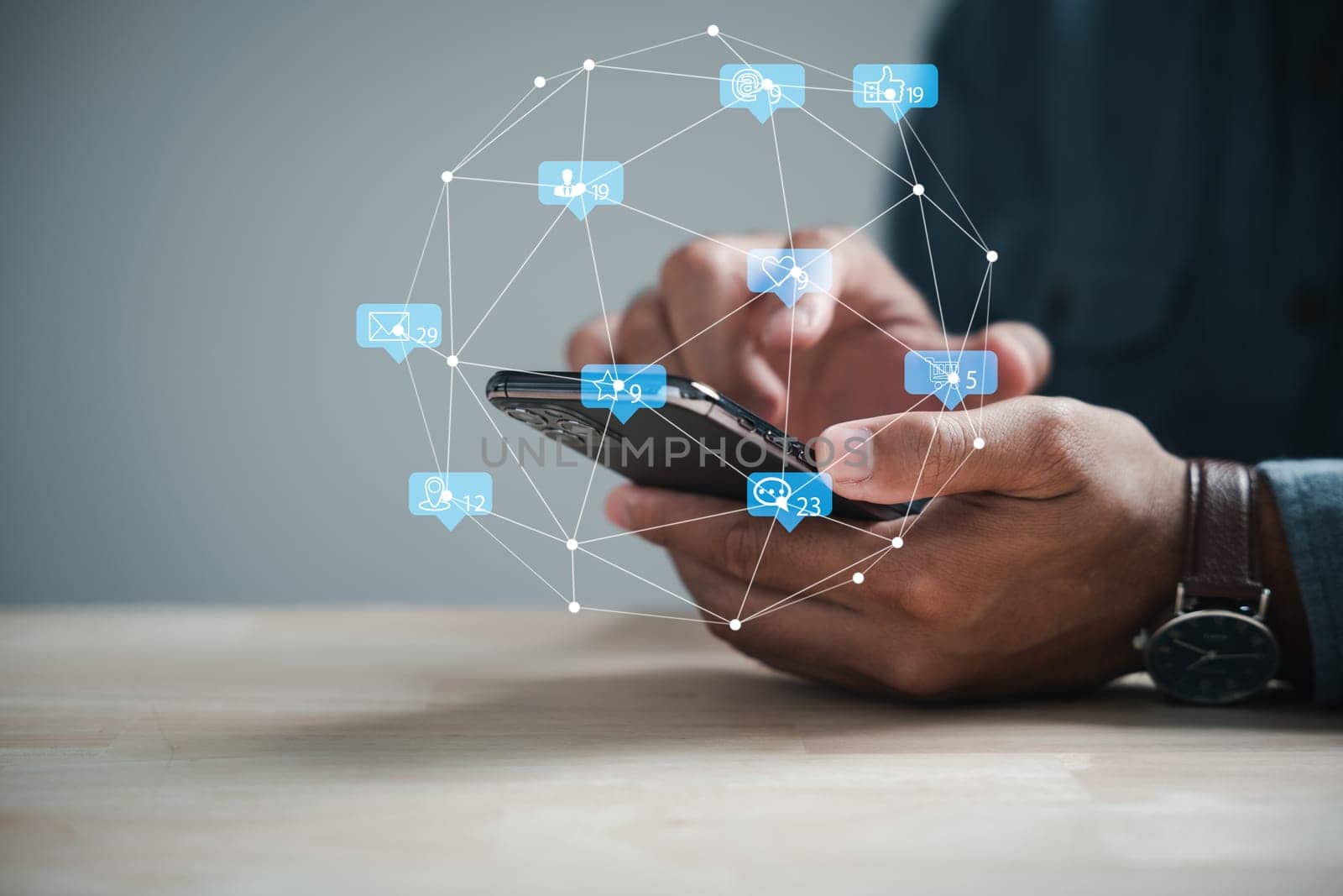 Mans hand engaged with smartphone, typing live chat and social network concepts. Home office setting, chat box icons emerging, exemplify modern communication trends. Social media marketing technology