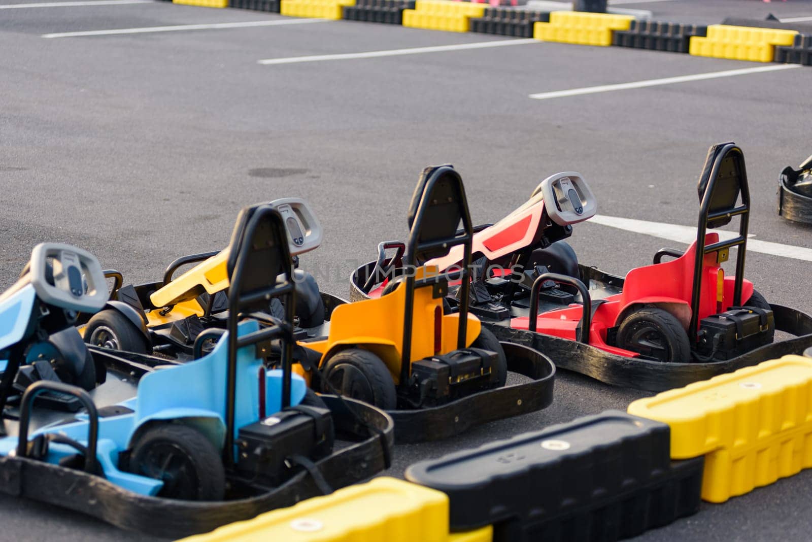 Colorful recreational Go-kart race excitement. Go kart machines lined up on the track, ready for high-speed motorsport action and thrilling competition.