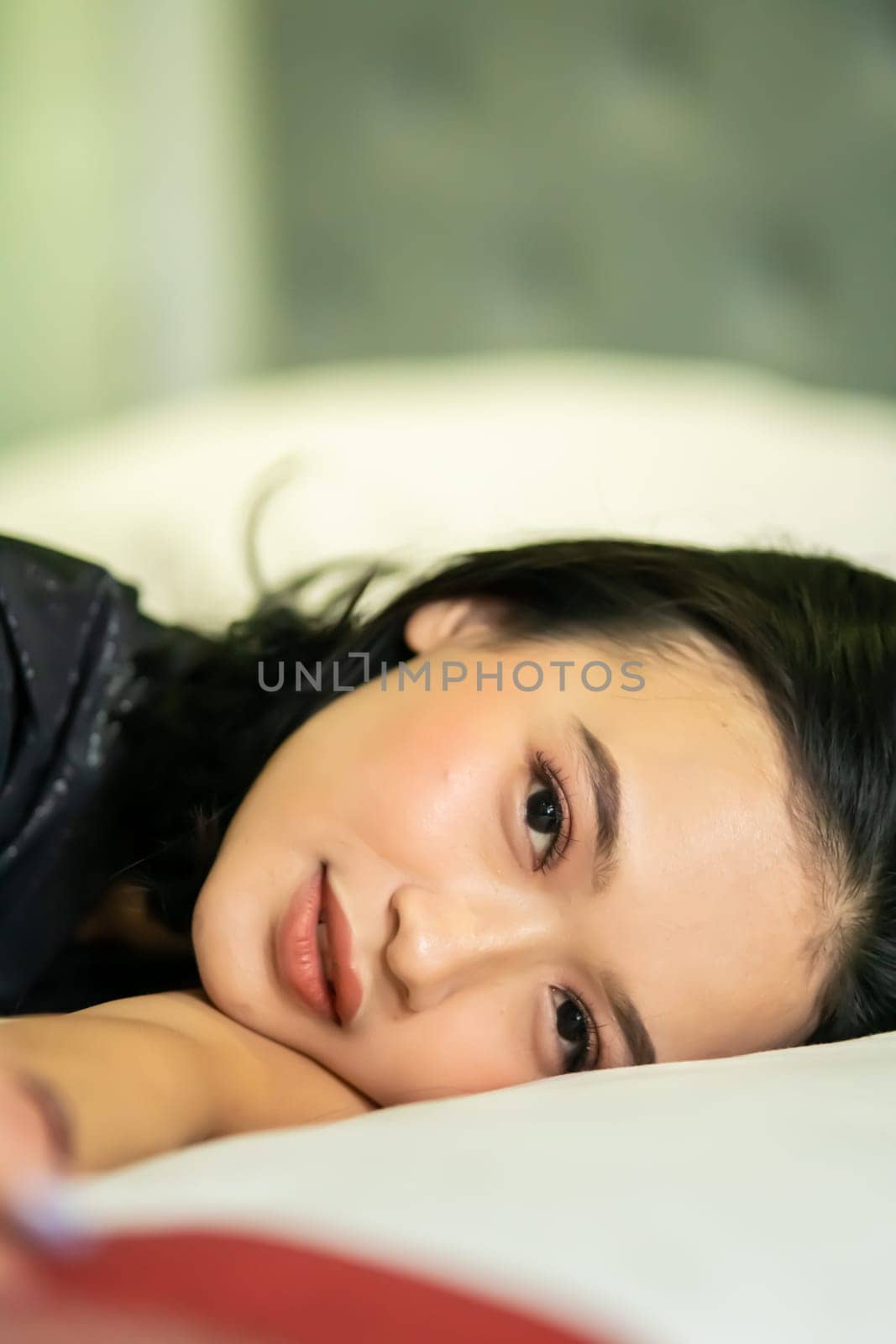 Indonesian women sleeping alone in her bad and she have a black hair while wearing a black dresses