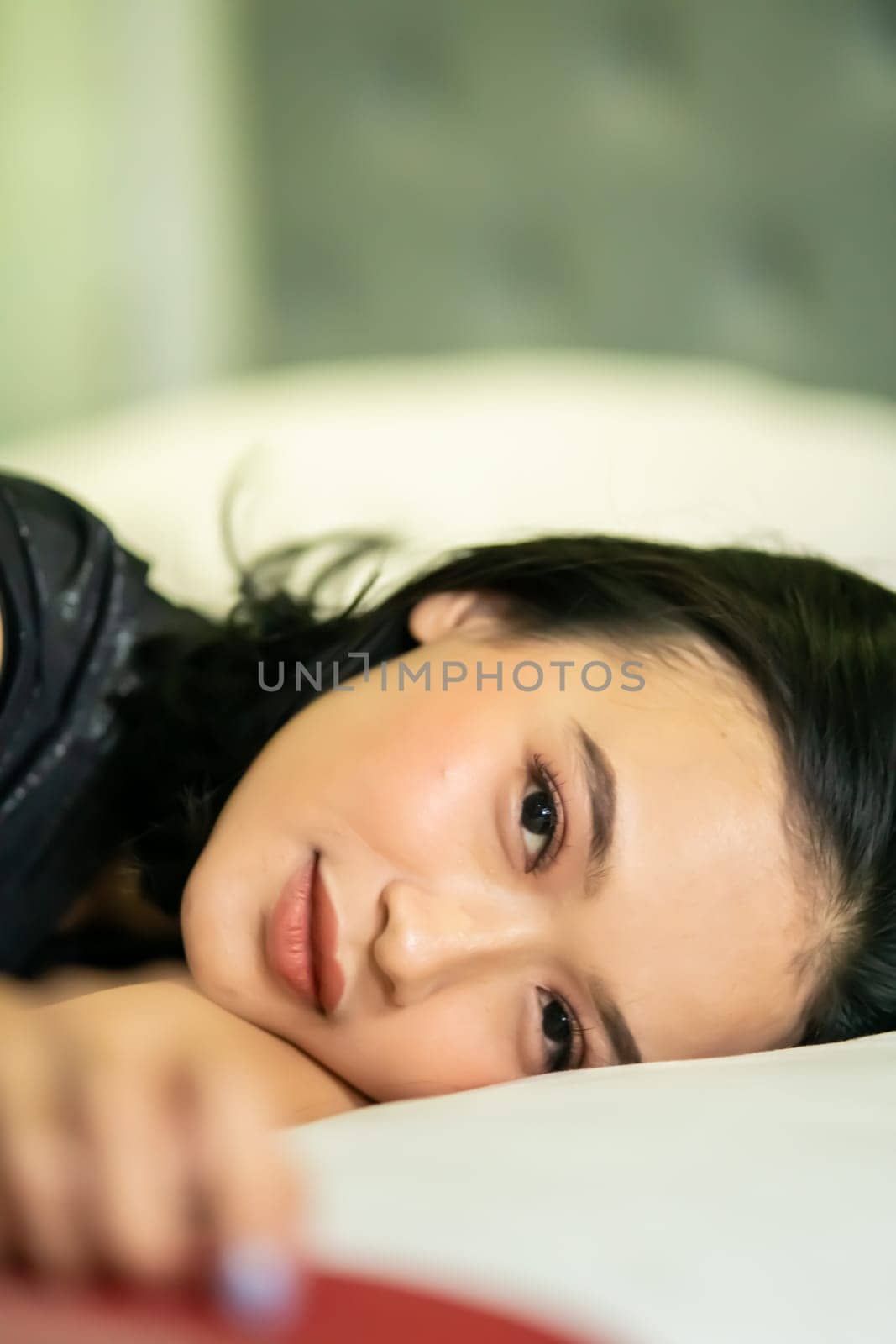 Indonesian women sleeping alone in her bad and she have a black hair while wearing a black dresses