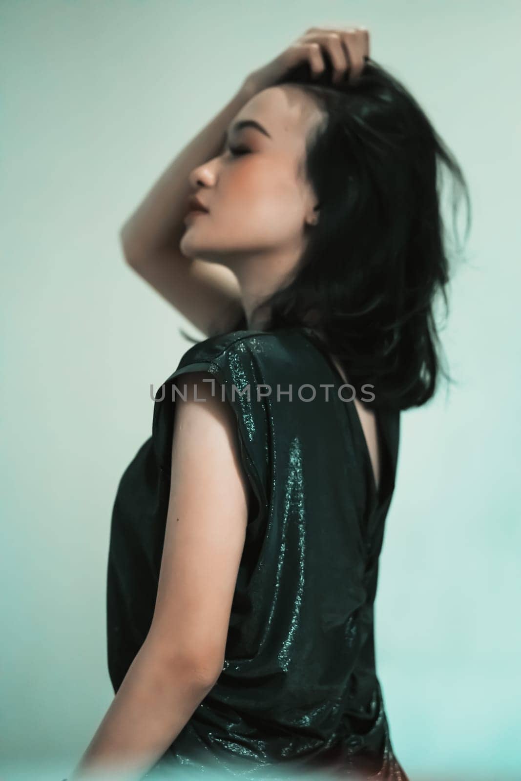 Rear look of Asian women wearing a black dress while she holding her hair and feeling sexy wearing it