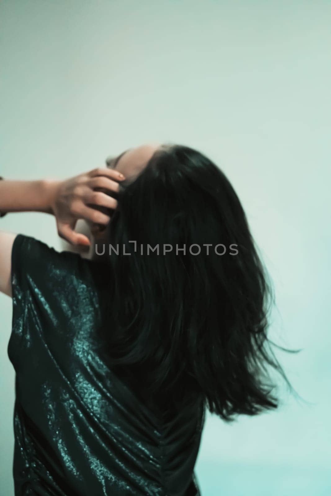 Asian women playing her black hair while wearing black dresses with smiling faces with green background