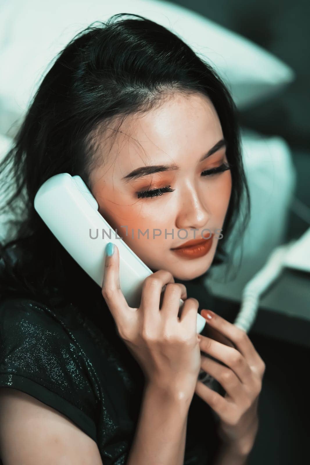 Beautiful women receive phone calls from a loved one in the night while she wearing a black dress and have a black hair