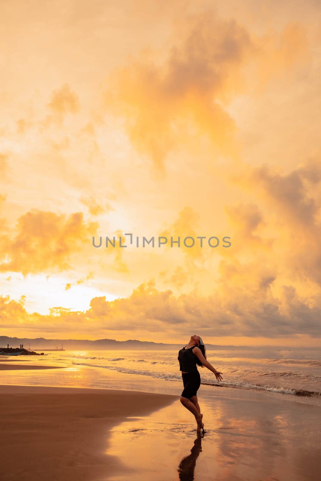 an Asian woman is enjoying the beauty of the beach and sea water in the late afternoon