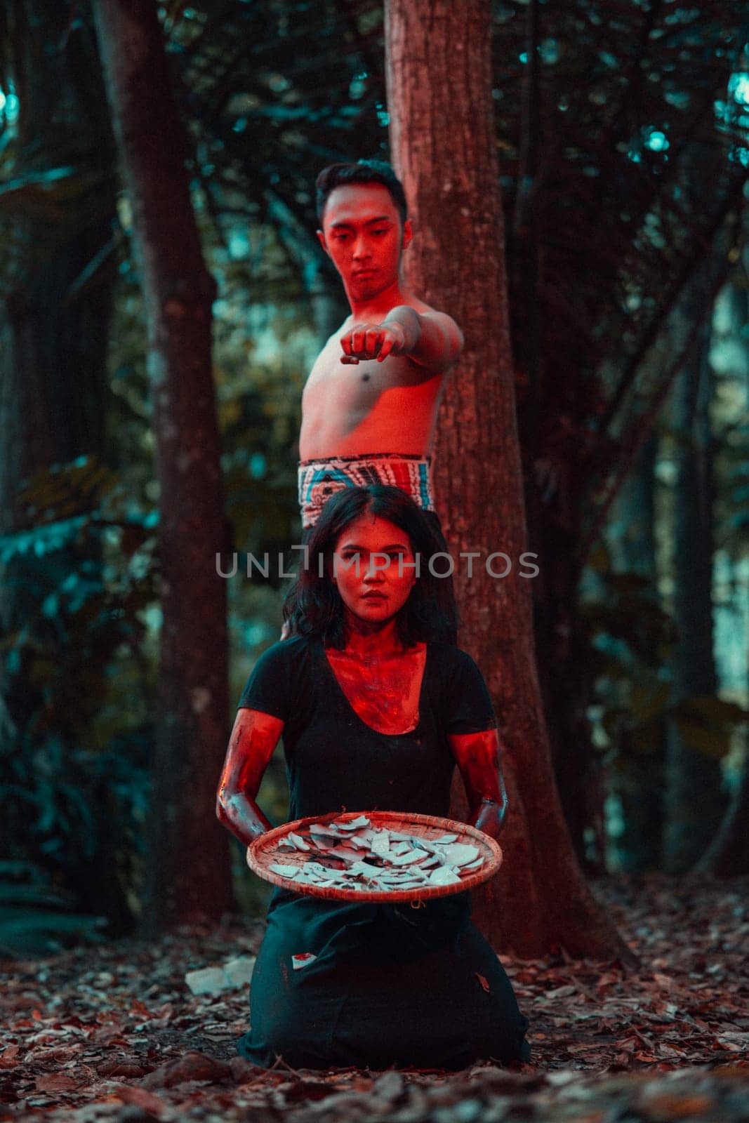 a couple of serial killers have bodies covered in blood and are performing a satanic ritual in the middle of a forest before sunset