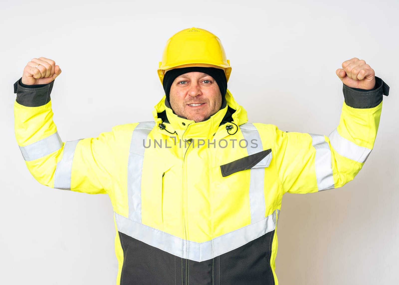 a man wearing a yellow working winter jacket and a yellow safety helmet . High quality photo