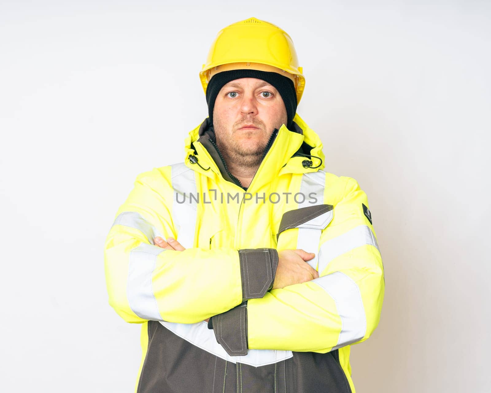 a man wearing a yellow working winter jacket and a yellow safety helmet . High quality photo