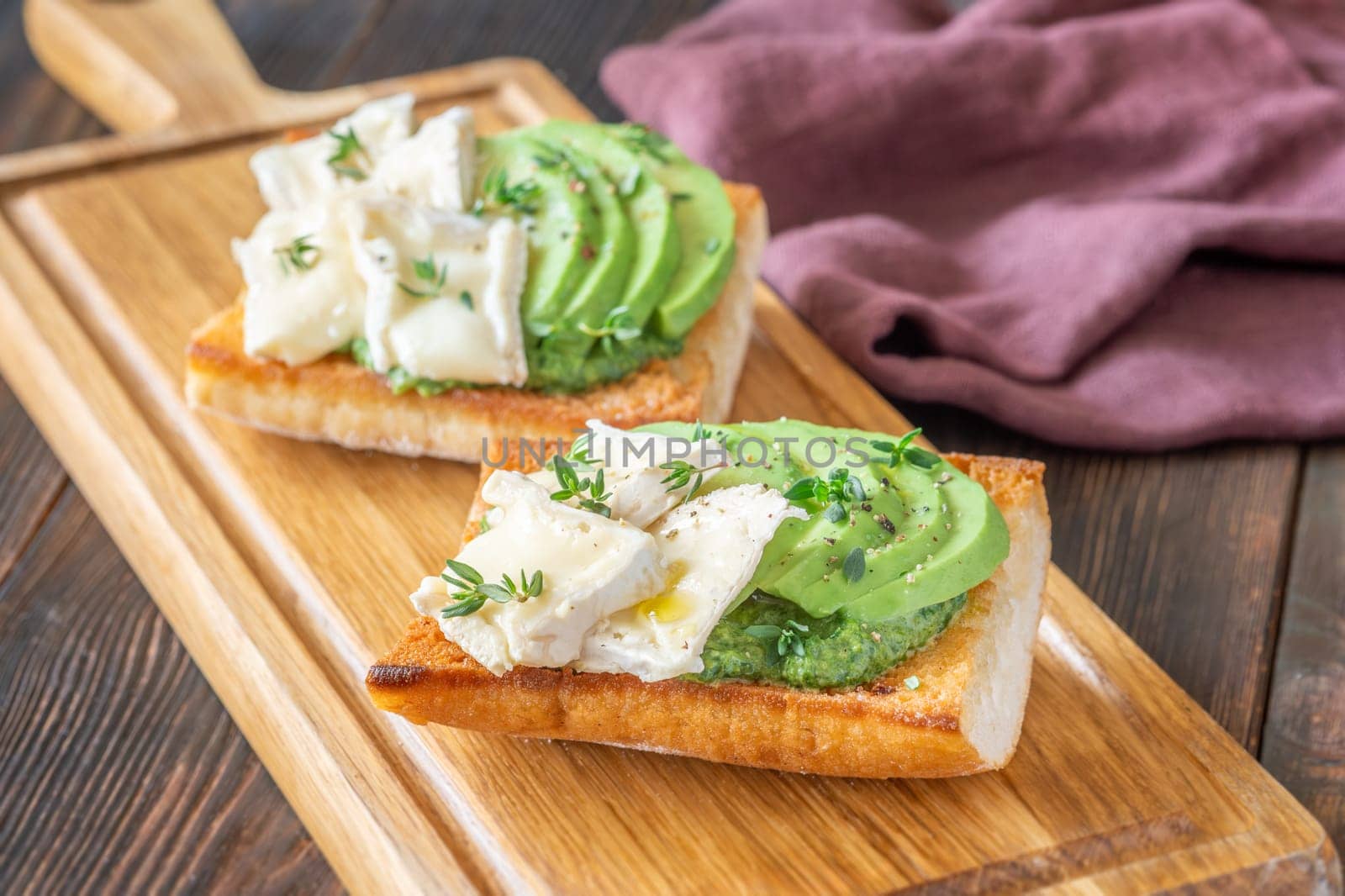 Toasted ciabatta sandwiches layered with brie, avocado, and creamy spinach, delicately herbed