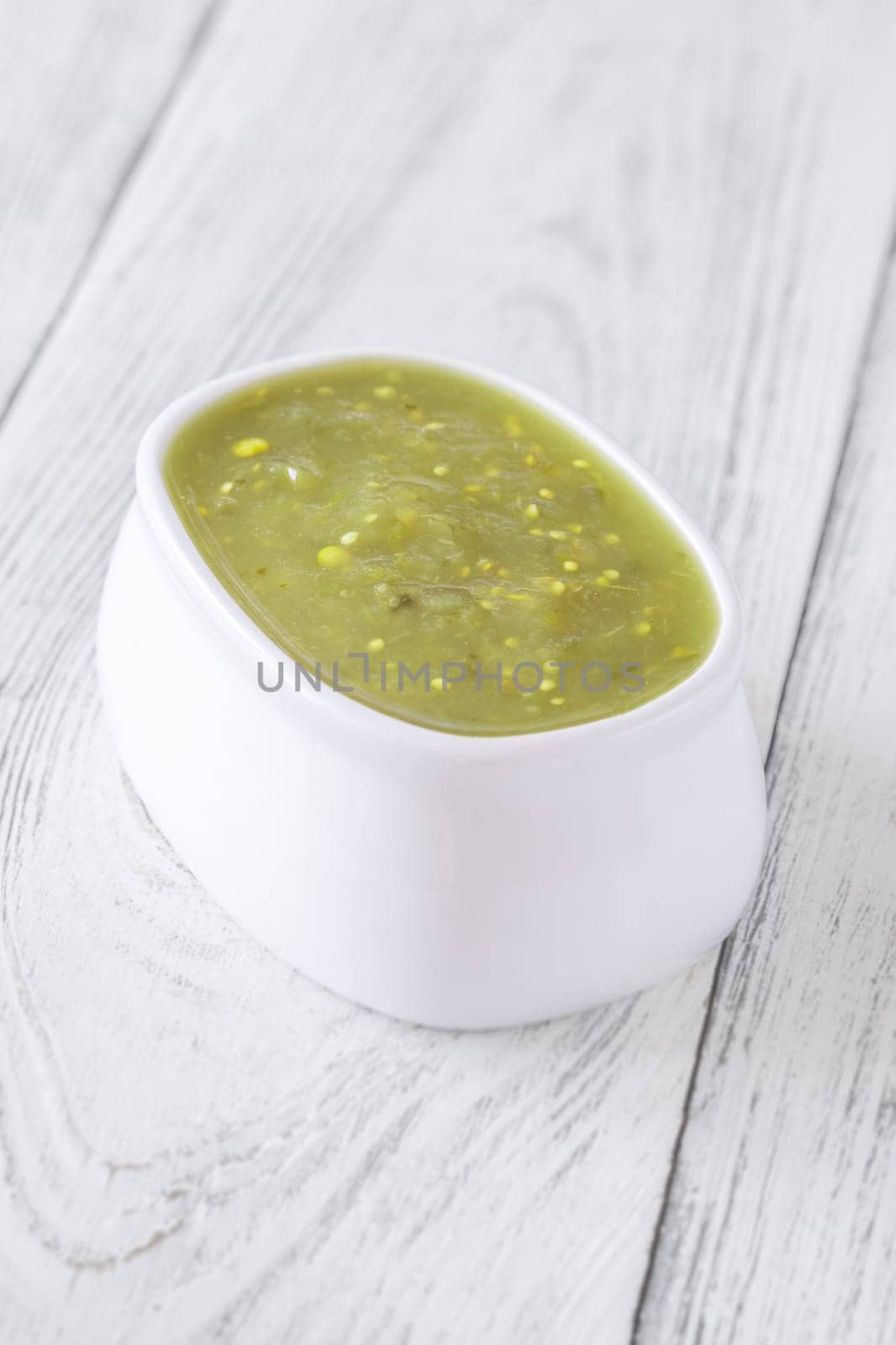 Bright green salsa verde swirled into bowl, tangy flavor with smooth texture