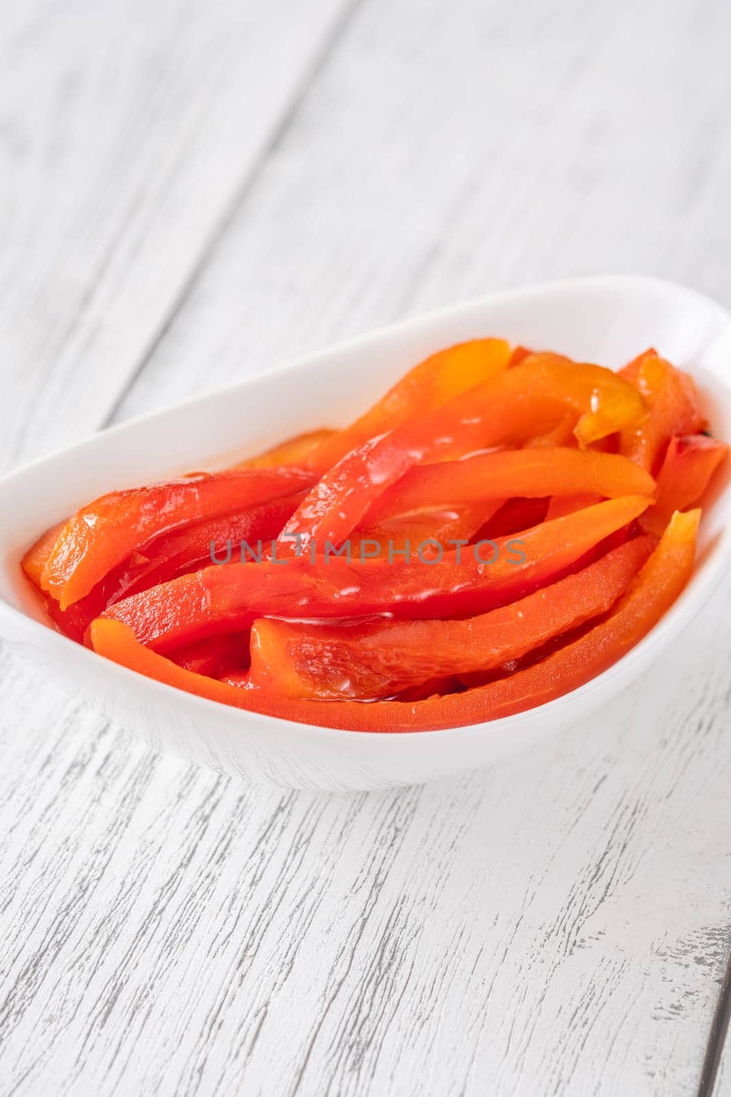 Charred red pepper strips arranged in bowl, smoky and sweet flavor showcased