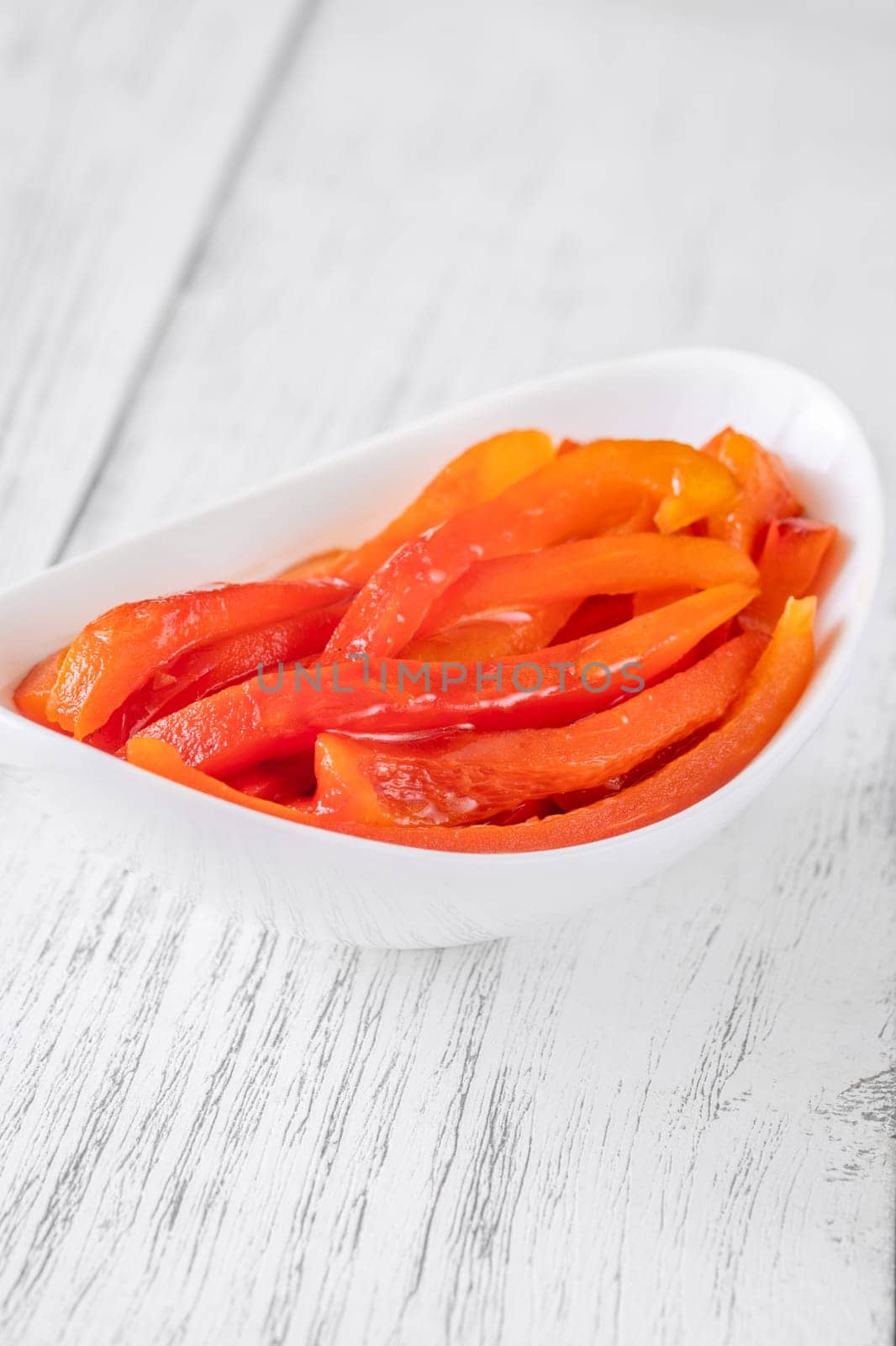 Charred red pepper strips arranged in bowl, smoky and sweet flavor showcased