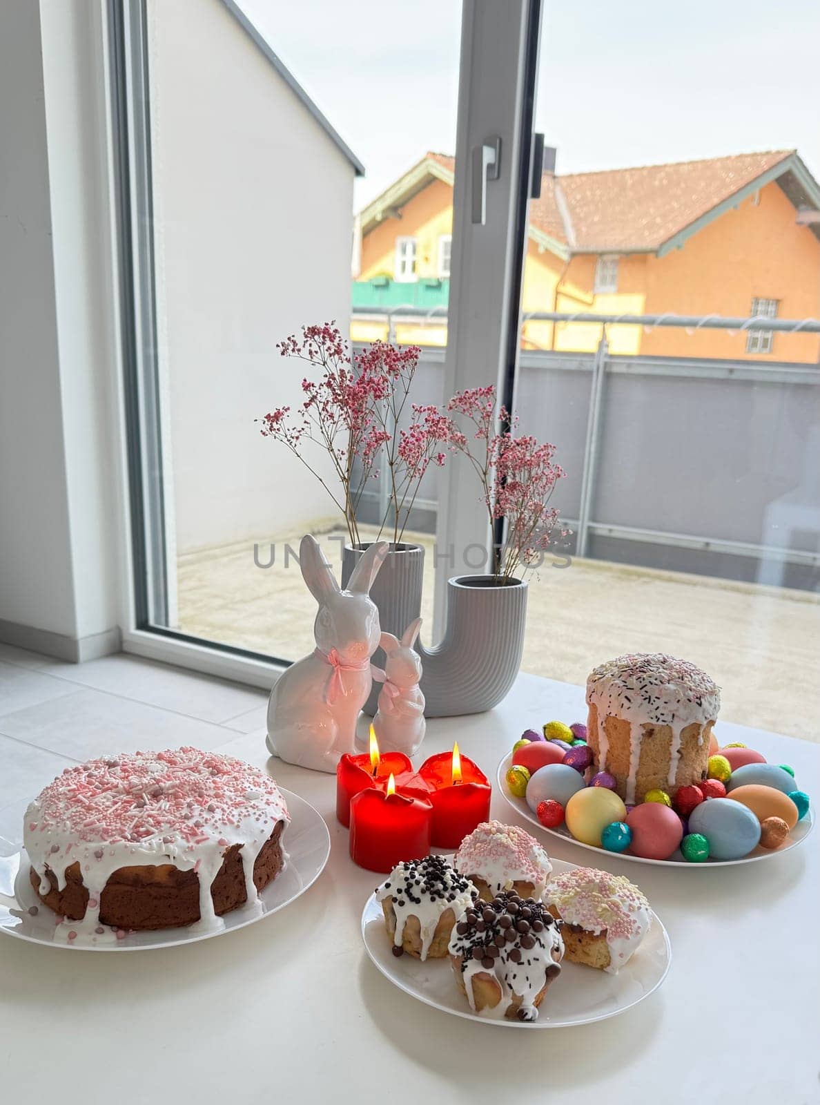 Festive dessert display showcases colorful cakes, decorative candles, and Easter-themed decorations, creating a joyful atmosphere ideal for celebration and gathering during spring festivities