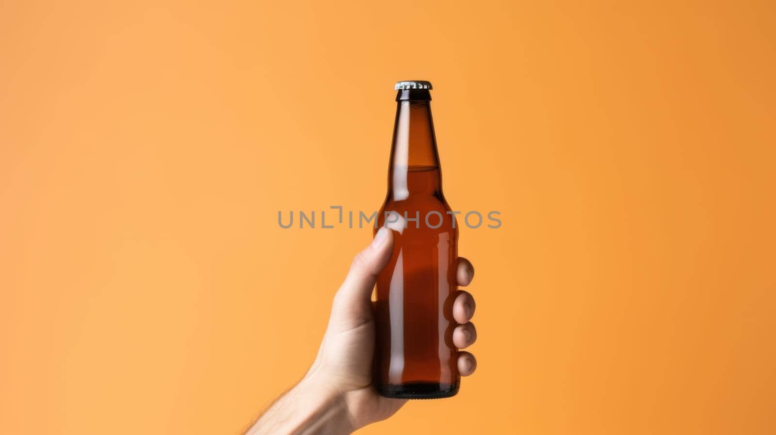 This close-up image features a hand gripping an amber beer bottle, set against a bright orange background. The bottles details are highlighted, while the blurred backdrop adds artistic flair.