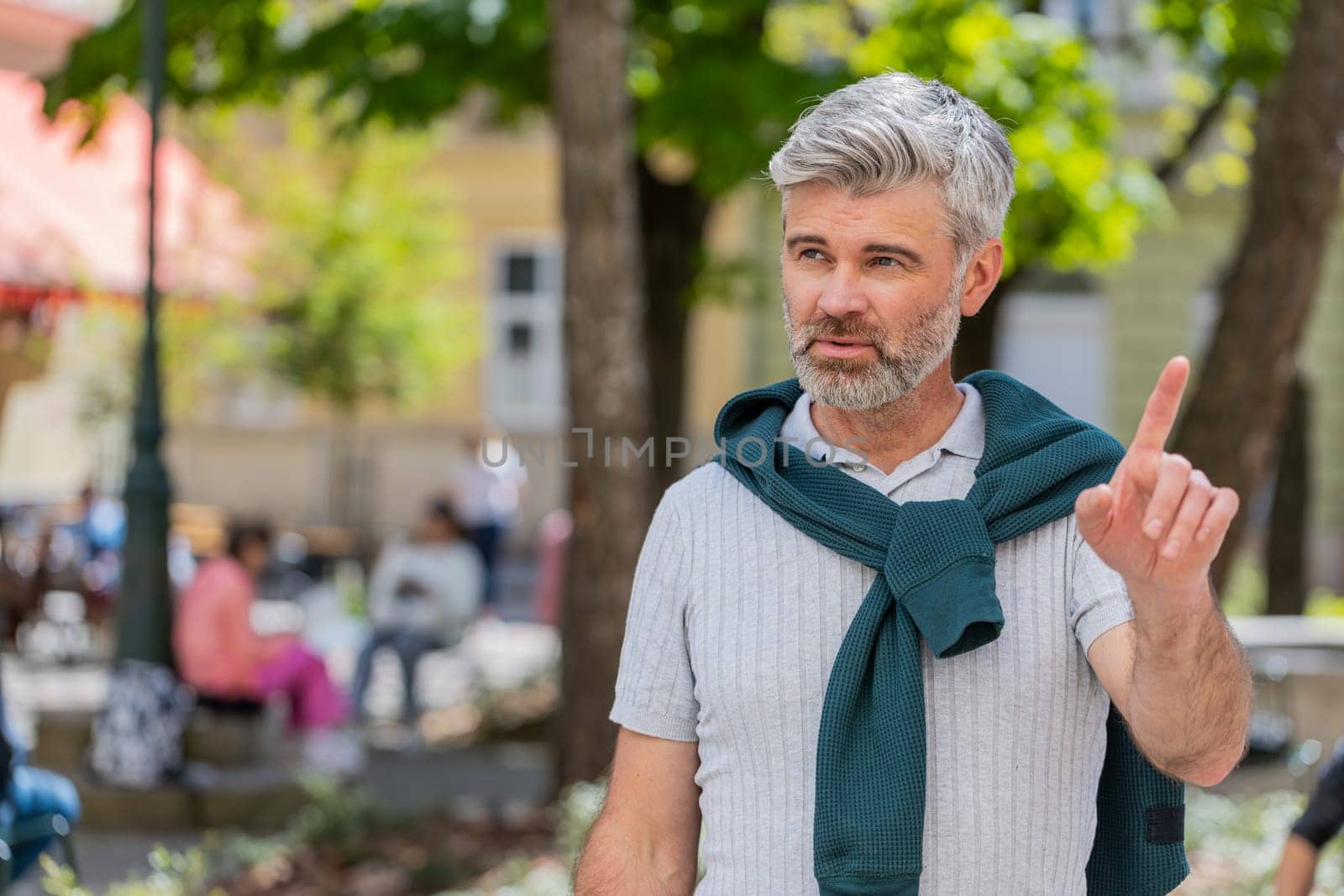 Displeased upset Caucasian man reacting to unpleasant awful idea, dissatisfied with bad quality, wave hand, shake head No, dismiss idea, don't like proposal. Mature adult guy traveler on city street.