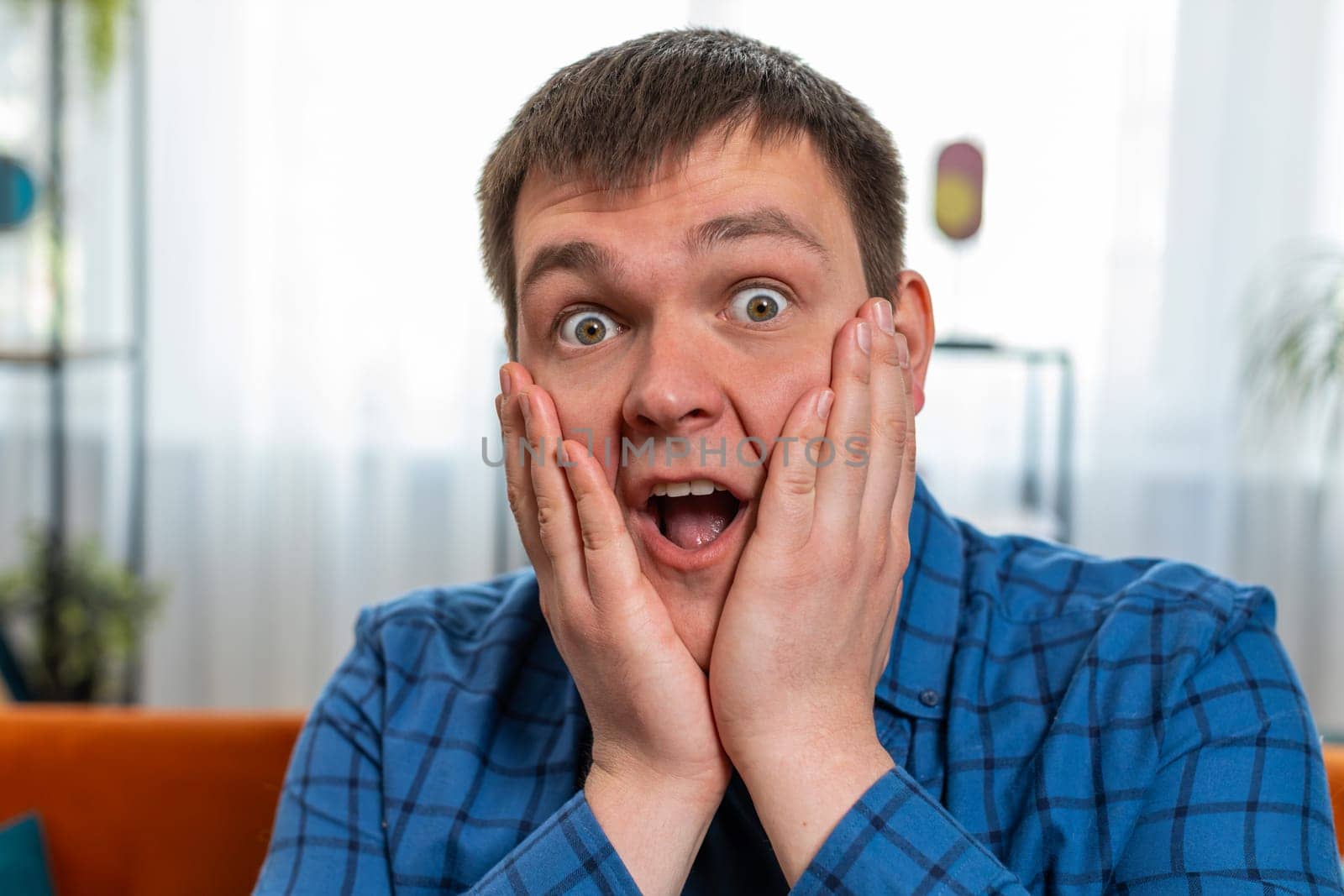 Oh my God, Wow. Excited amazed man surprised looking at camera with big eyes, shocked by sudden victory, good win news, celebrating success triumph. Portrait of fat Caucasian guy at home room.