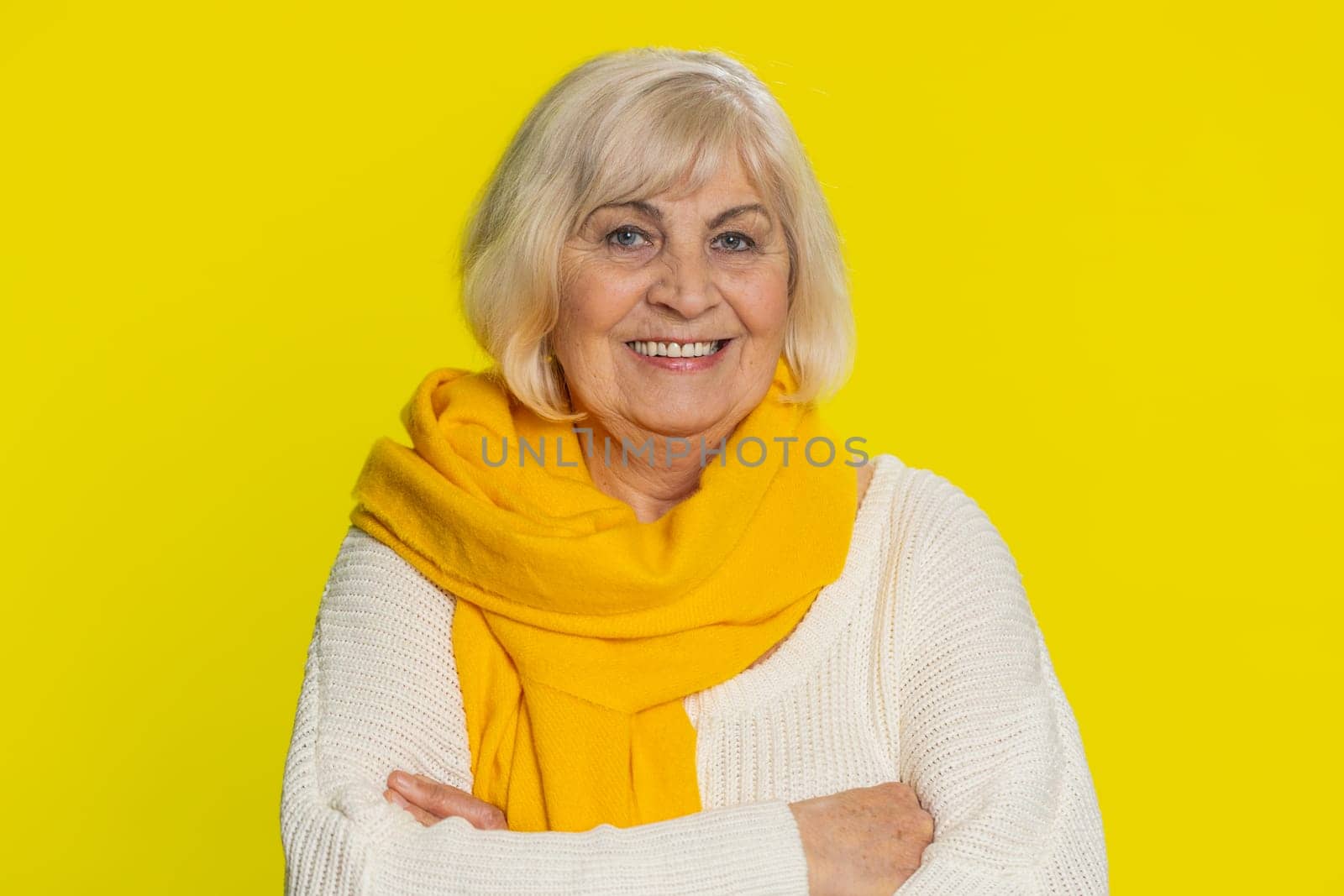 Portrait of happy senior old woman smiling friendly, glad expression looking at camera dreaming, resting relaxation feel satisfied good news. Mature grandmother pensioner on yellow background indoors