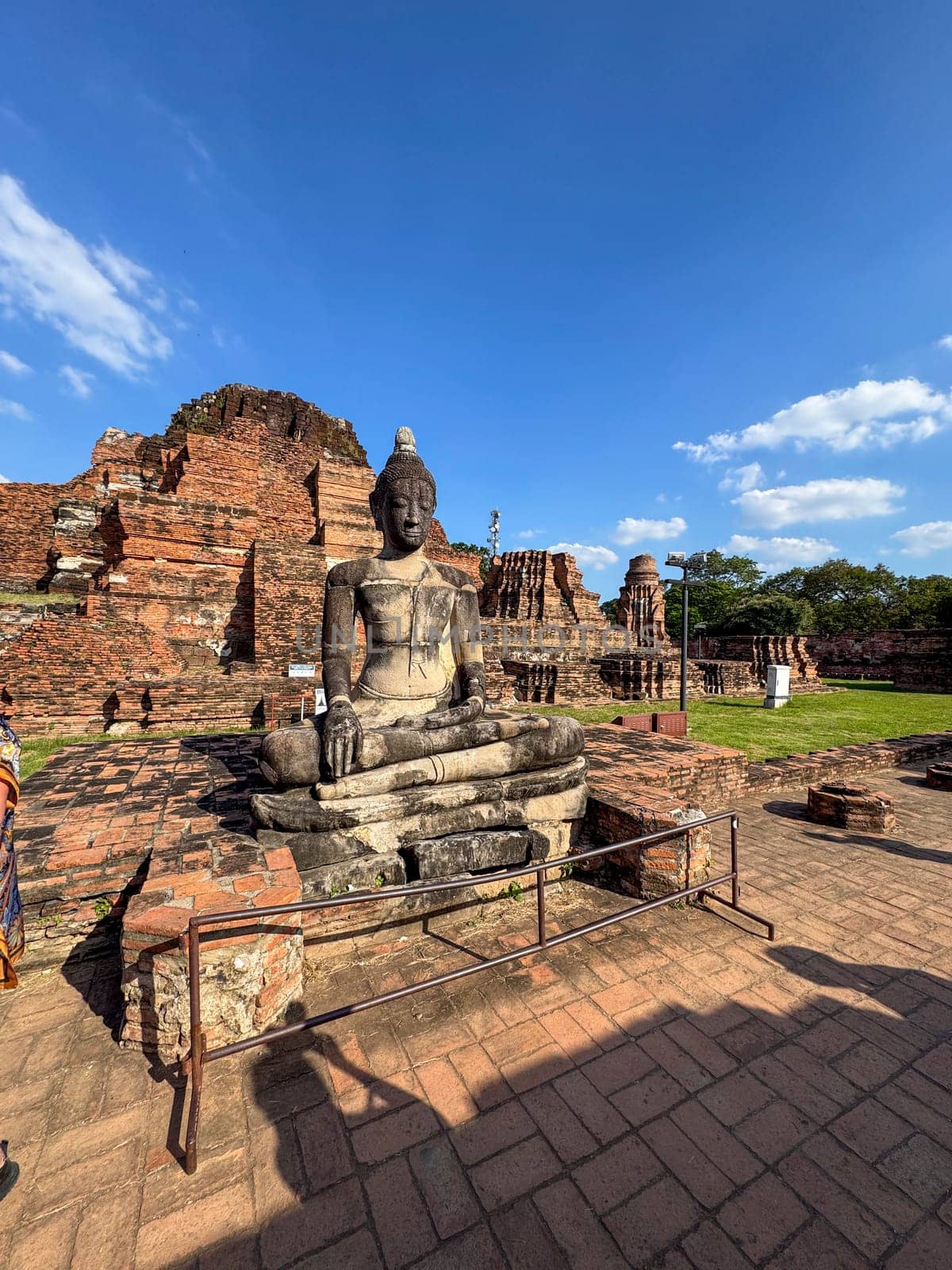 Sacred stone traditional statues of Buddha sit in a historic monument temple, Wat Maha That landmark representing faith and spirituality. Beautiful sacred religious destination in Thailand.
