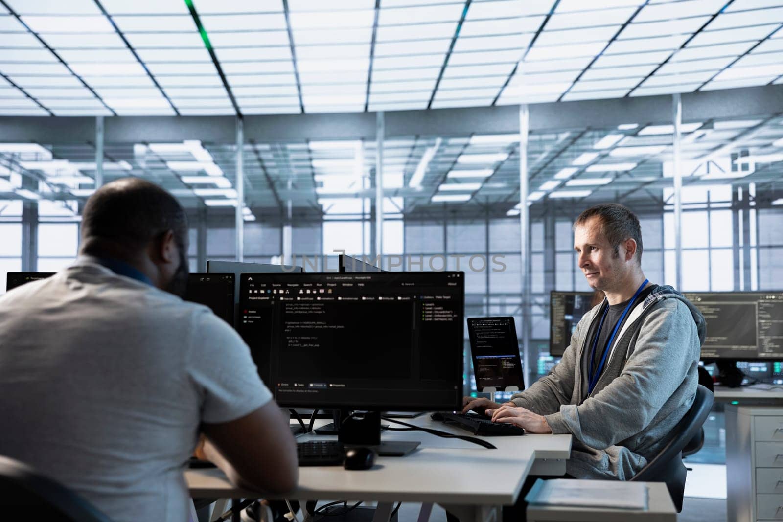 Computer scientists in data center coordinating deployment of server architecture, improving data processing speed. Server farm specialists expert configuring and testing hardware