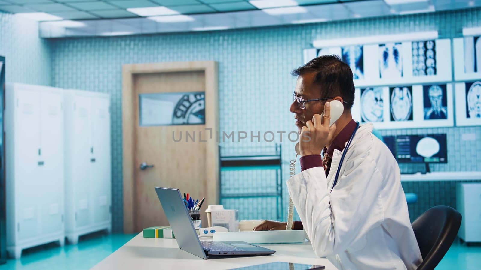 Male physician examining x ray test results in his medical cabinet, providing a diagnostic for a sick patient. Doctor studying hospital records and sharing his expertise in the industry. Camera B.