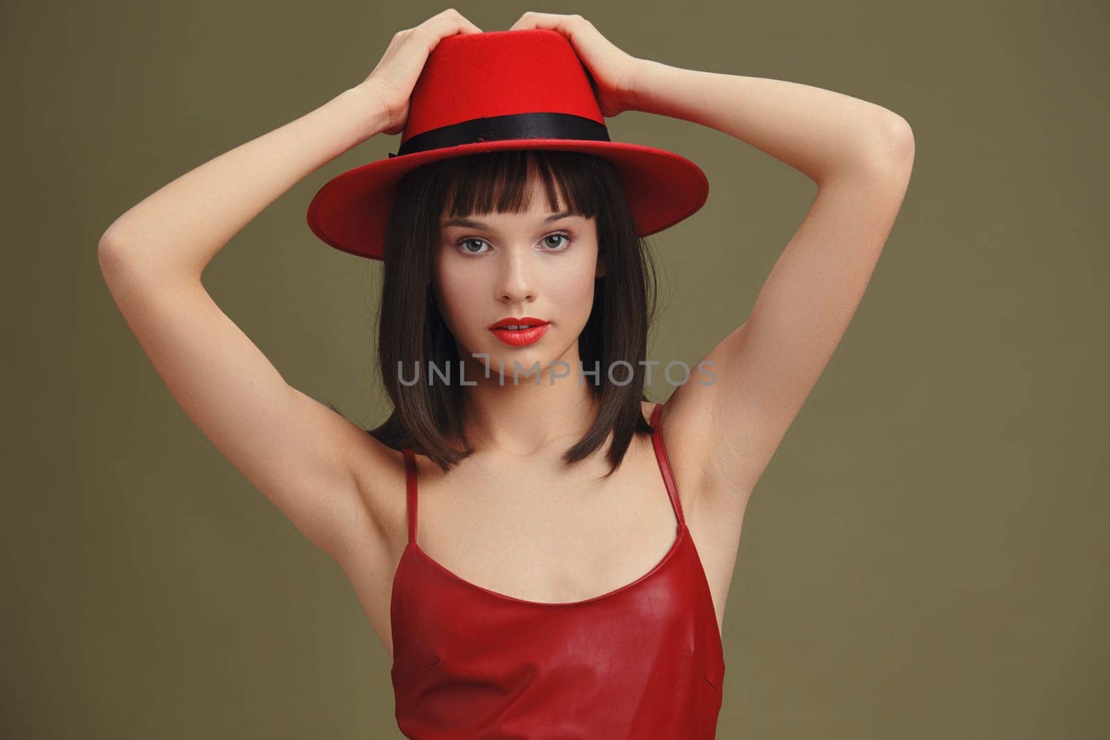 Red dress, woman, hat, posing, hands on head, hair pulled back a woman in a vibrant red dress and matching hat poses elegantly for the camera, with her hands resting on her head and her hair neatly