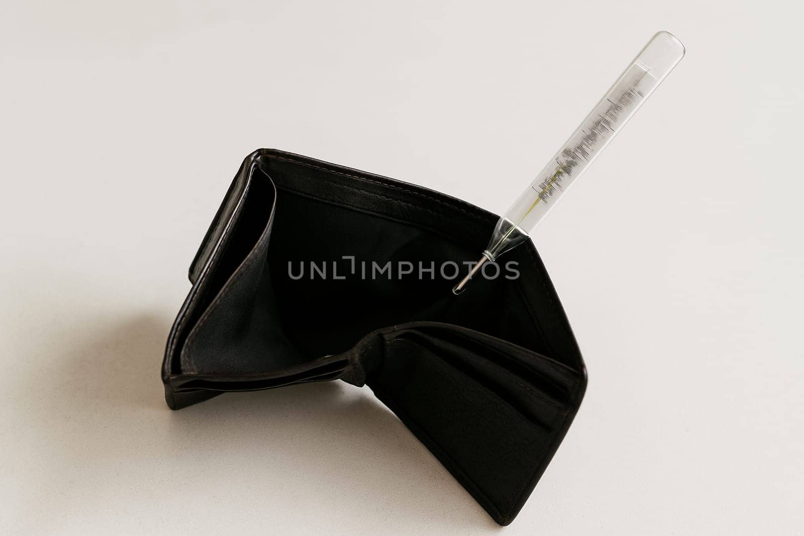 AI generated realistic empty men's wallet with medical thermometer showing high temperature symbolizing financial crisis and economic emergency concept white background money problem metaphor