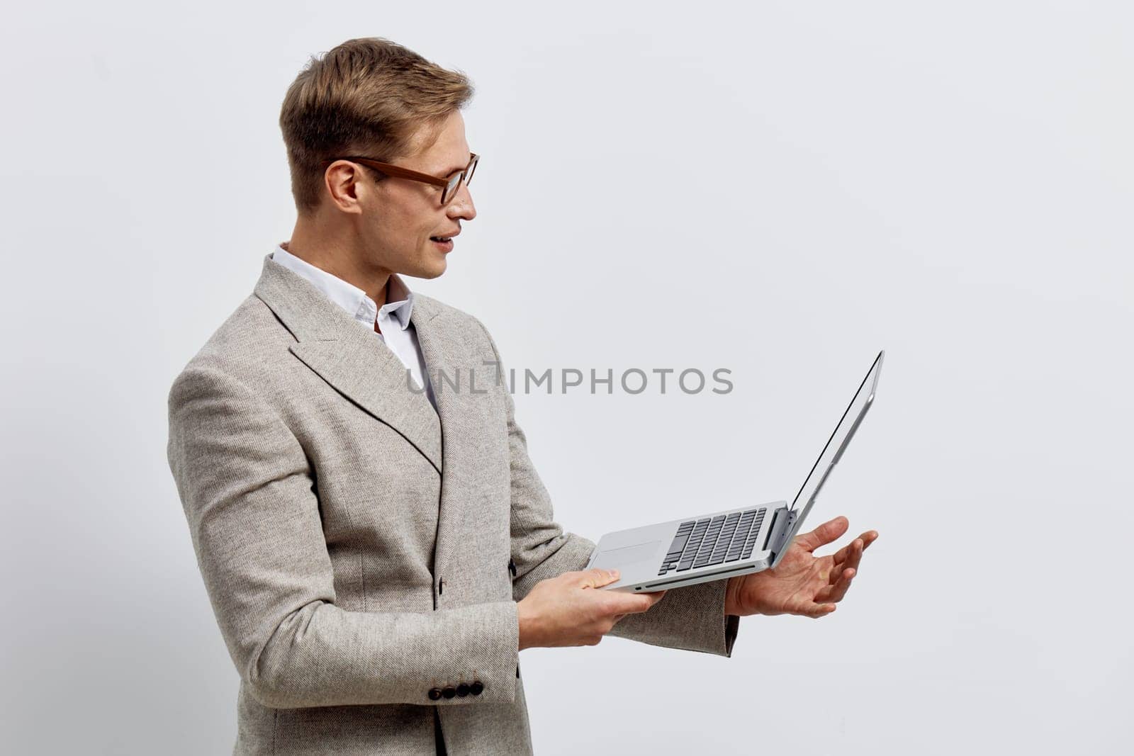 young caucasian man working laptop wearing beige jacket and glasses looking at screen with concentration isolated on plain background remote freelance digital nomad concept of online work lifestyle