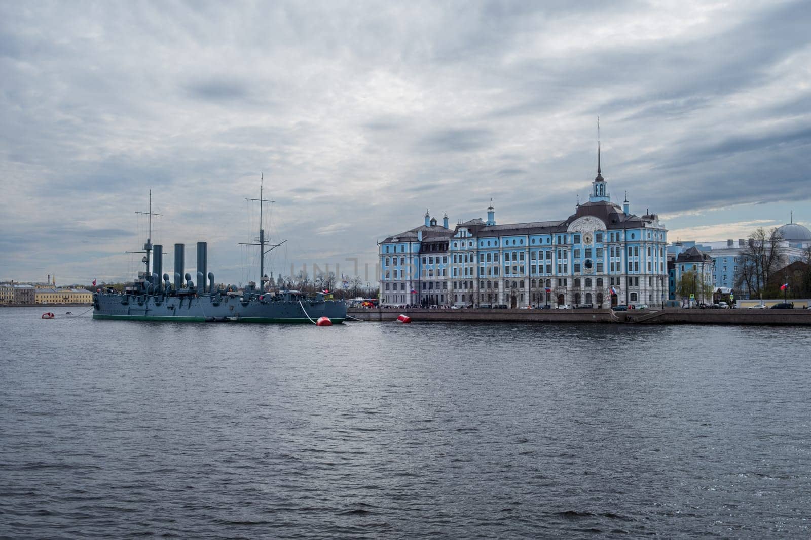Saint Petersburg, Russia - 02.05.25. Cruiser Aurora moored near Nakhimov Naval school on the Neva River in St. Petersburg. Iconic landmarks represent Russia's maritime heritage and educational legacy.