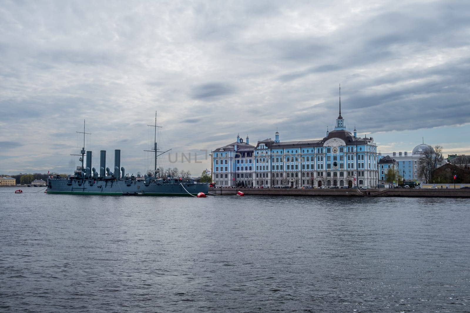 Saint Petersburg, Russia - 02.05.25. Cruiser Aurora moored near Nakhimov Naval school on the Neva River in St. Petersburg. Iconic landmarks represent Russia's maritime heritage and educational legacy.