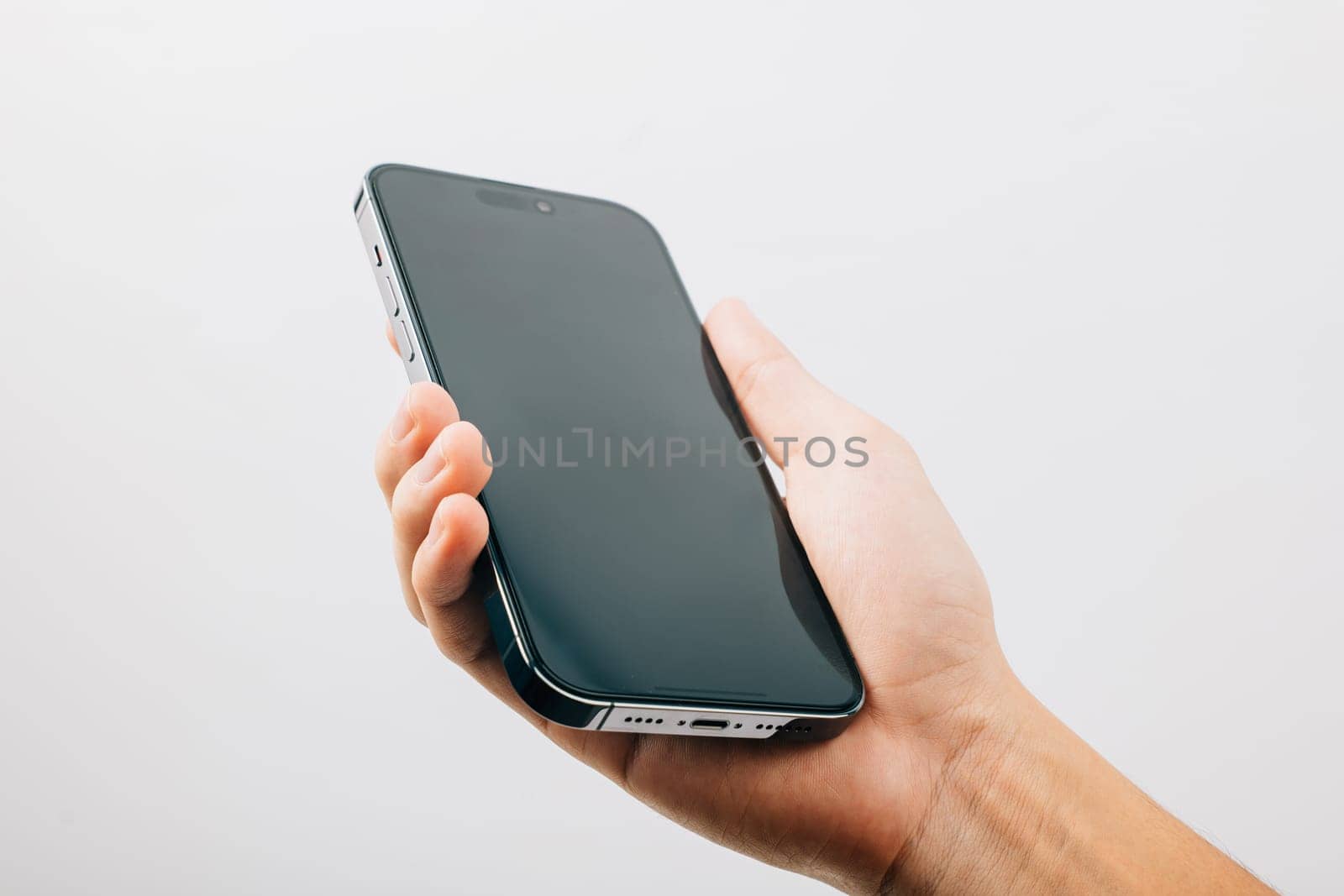 A hand holding a black cell phone isolated on white background, Man hand holding black smartphone mockup blank screen display, web site design application