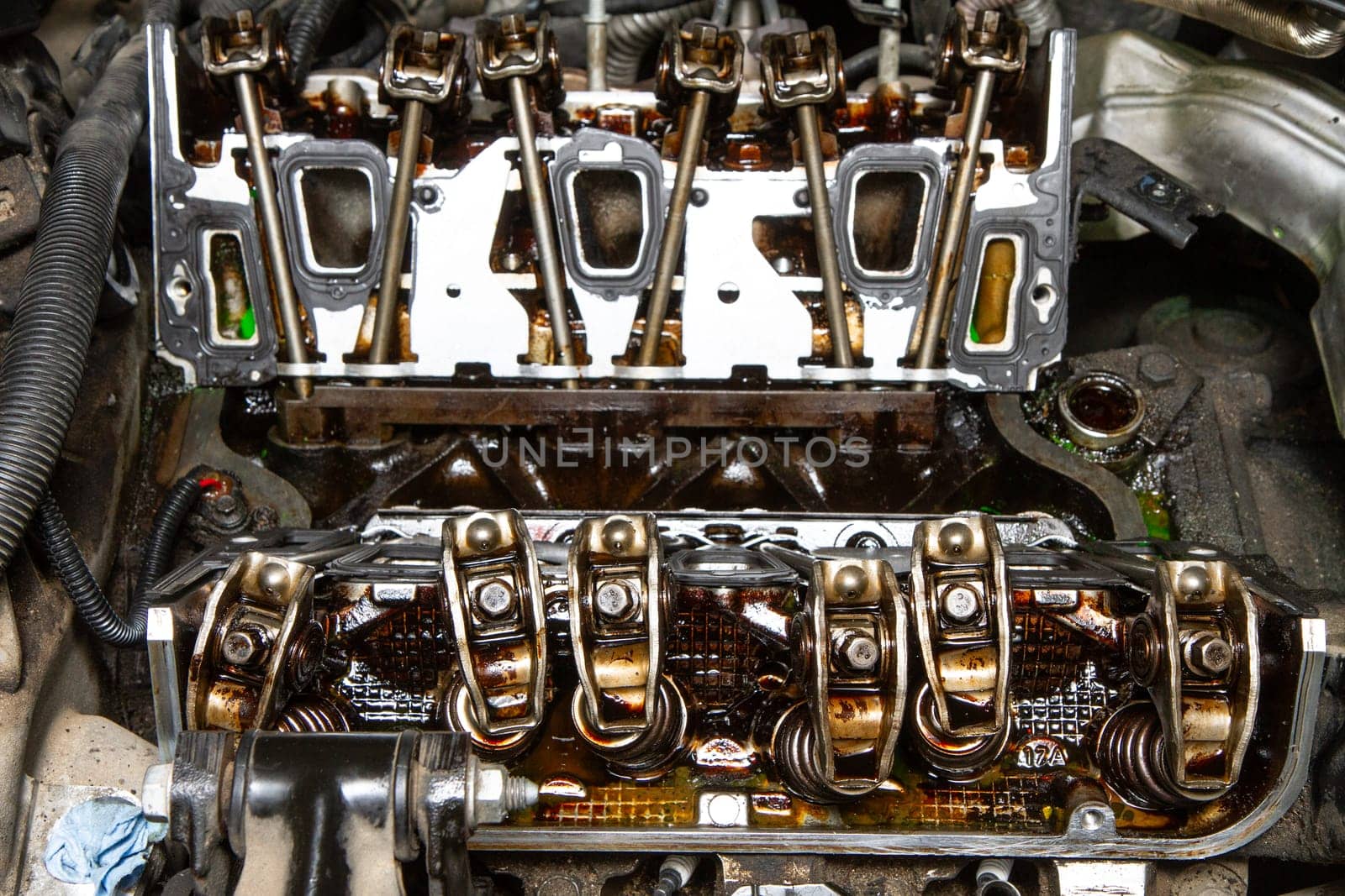 The engine of a car is open and the valves are visible. The valves are rusty and the engine is in need of repair