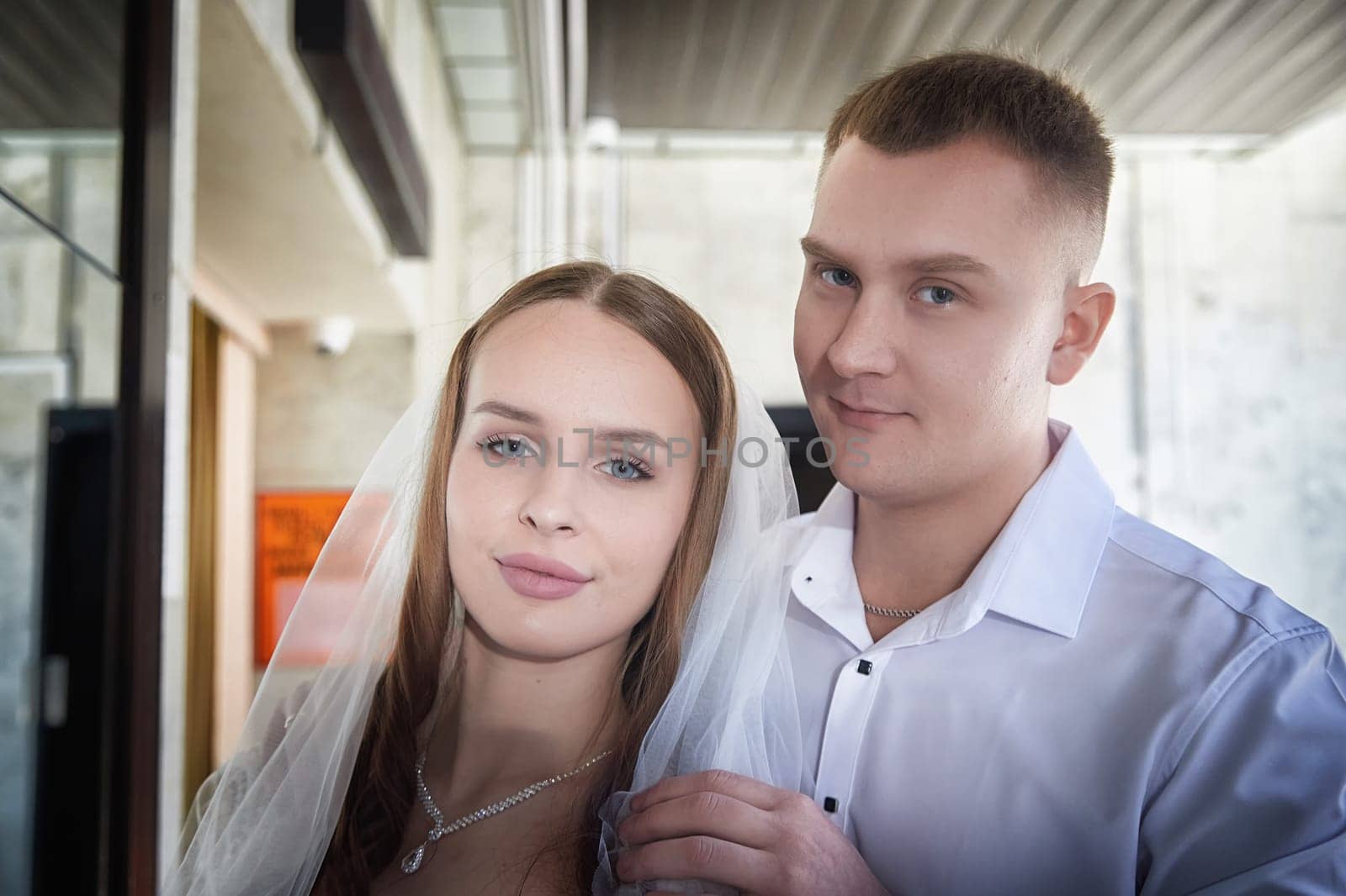 Groom and bride pose closely together, radiating love and happiness during their wedding registration at a modern venue.