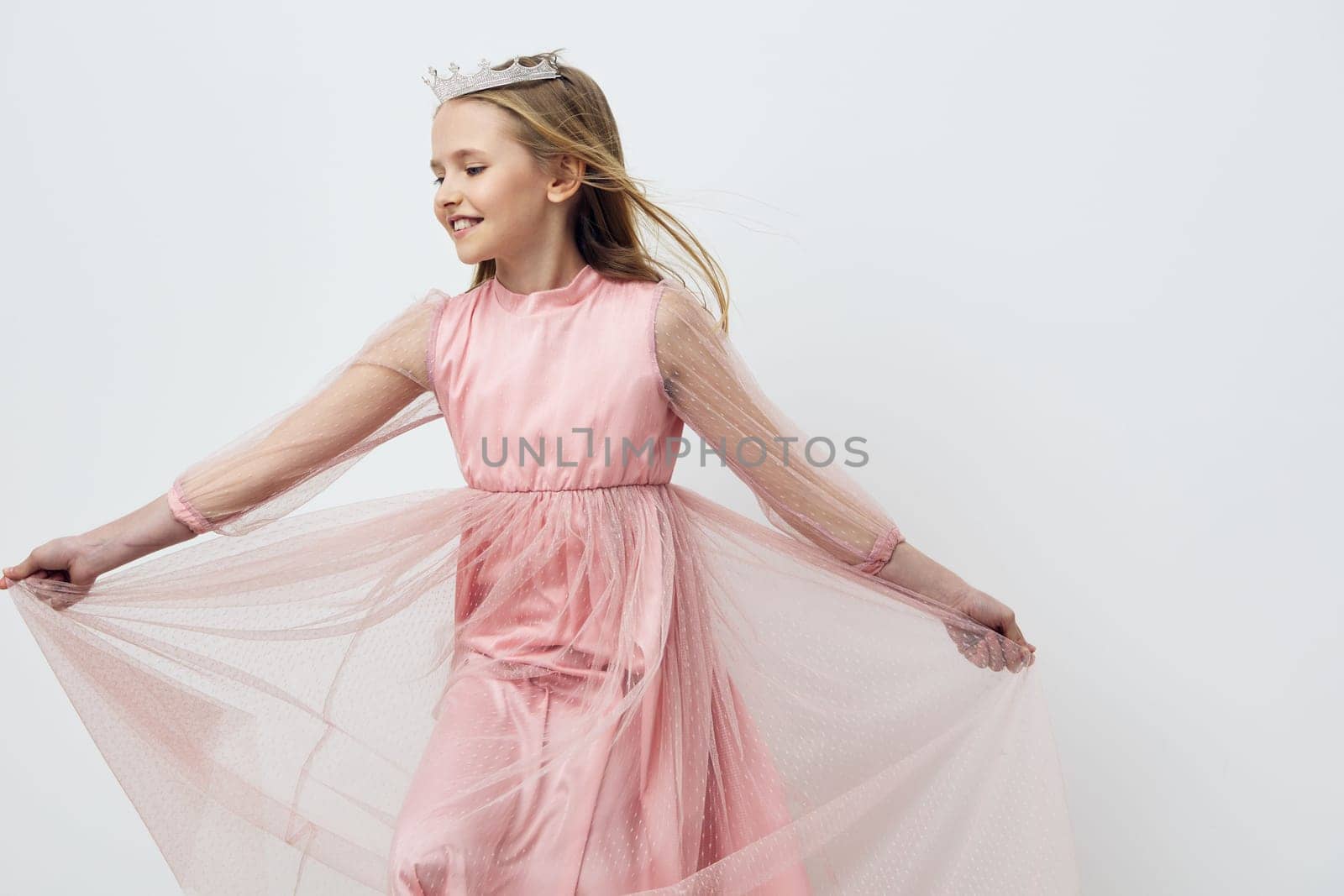 Delightful image of a cheerful young girl in a pink tulle dress, expressing happiness while twirling Ideal for children s fashion, joy, and special occasions
