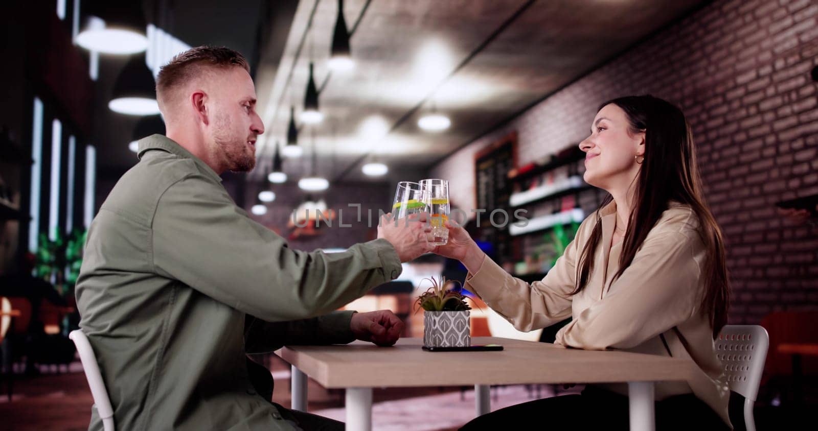 Couple Enjoying Wine And Dining At Romantic Evening Dinner Date