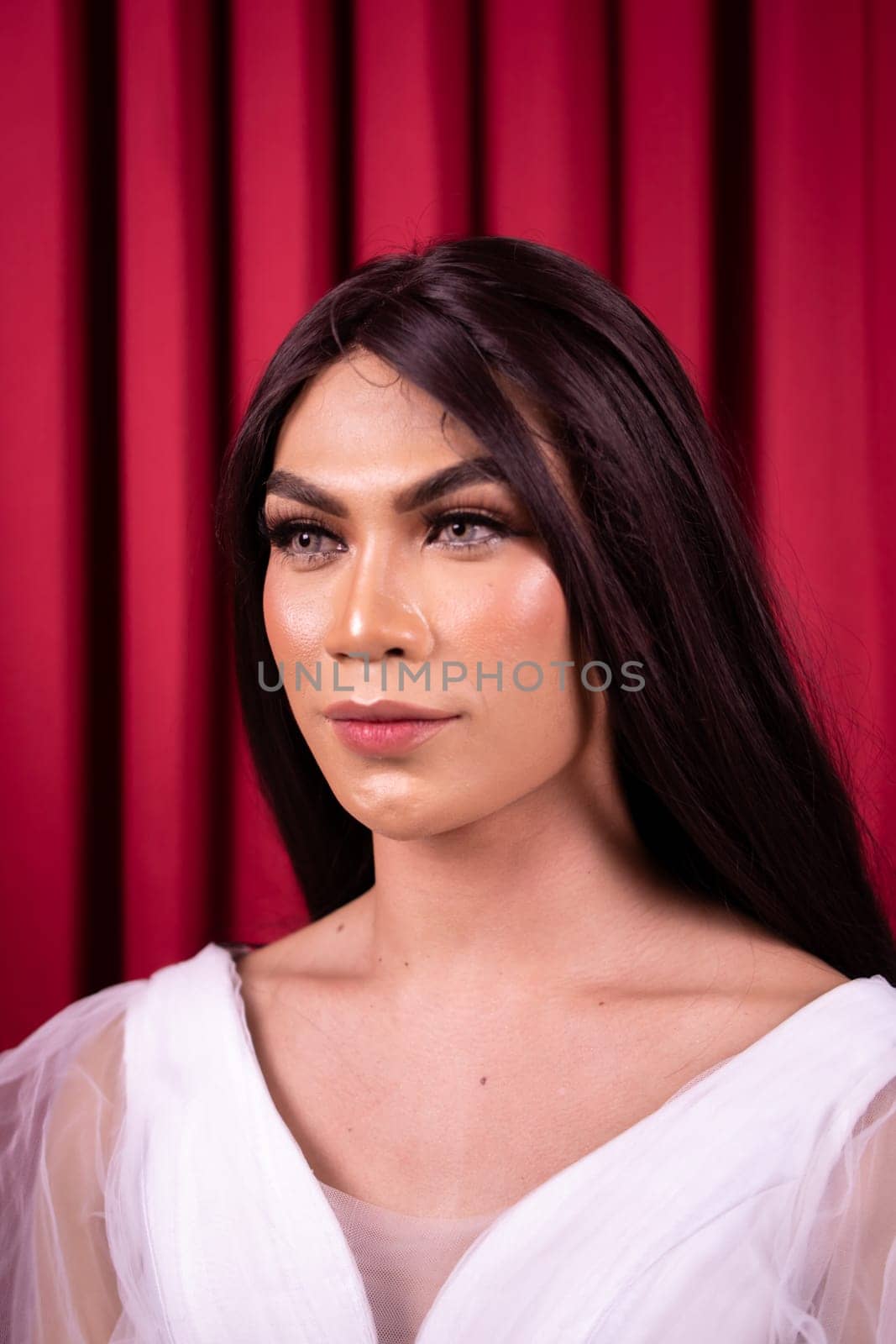 Luxury Asian woman in a white dress with a red curtain in the background inside the studio