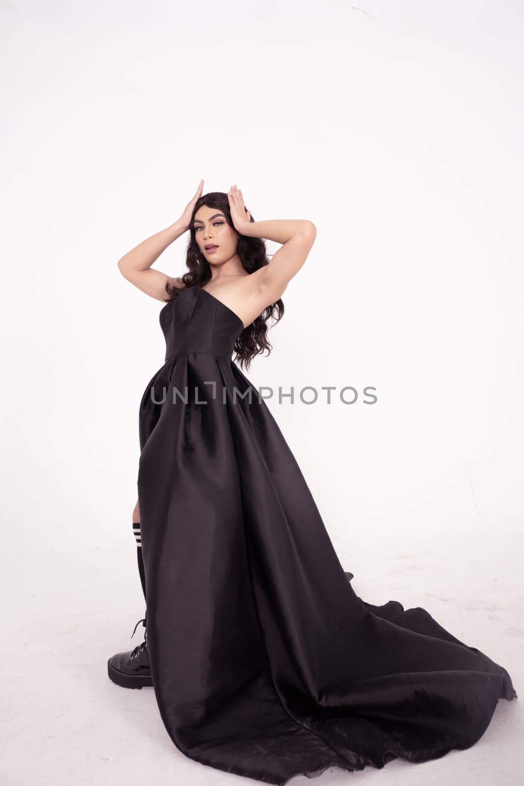 Asian woman in a black bride dress with a tail pose in a white room inside the studio