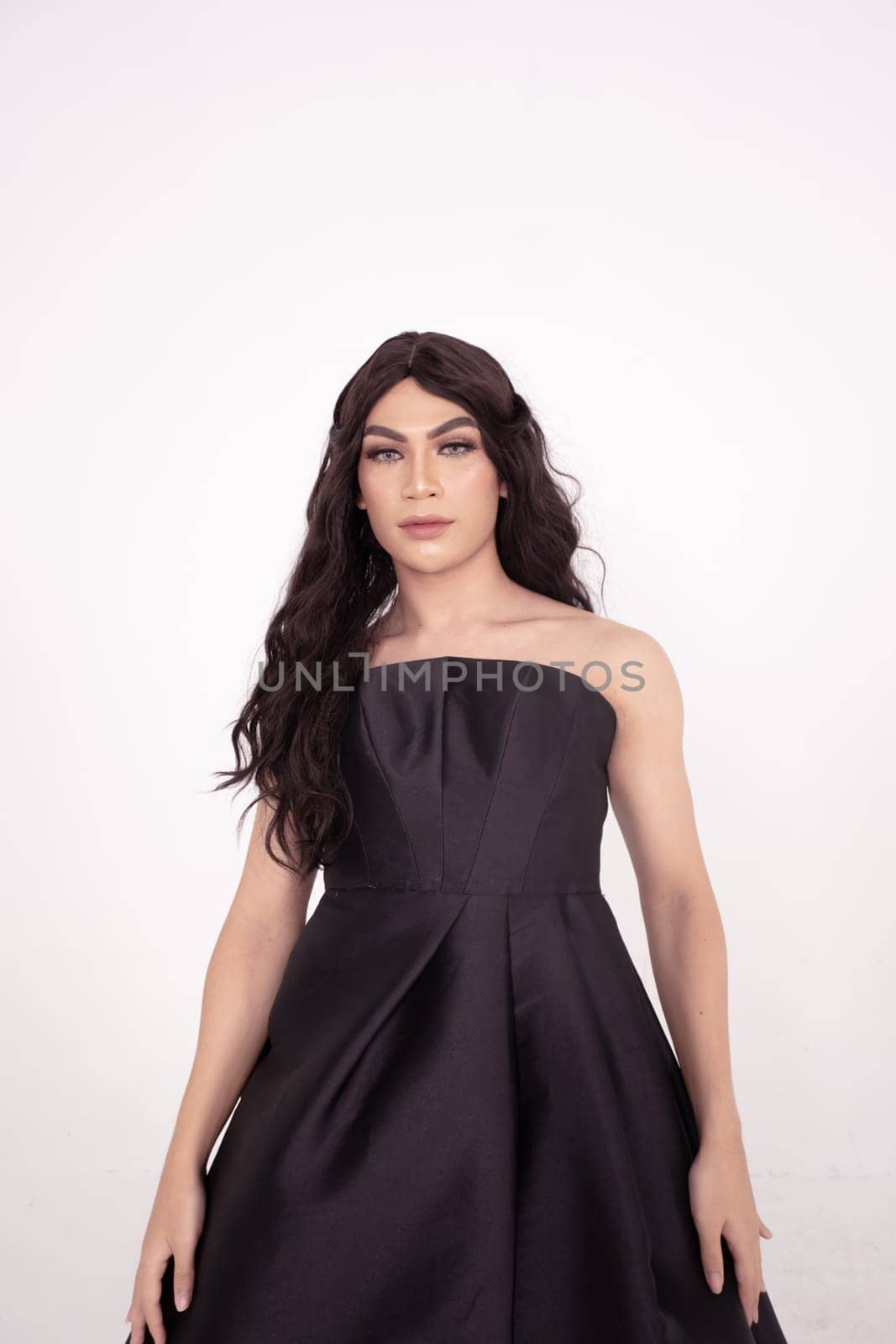 The wedding bride in black dress poses before the wedding ceremony in a white room