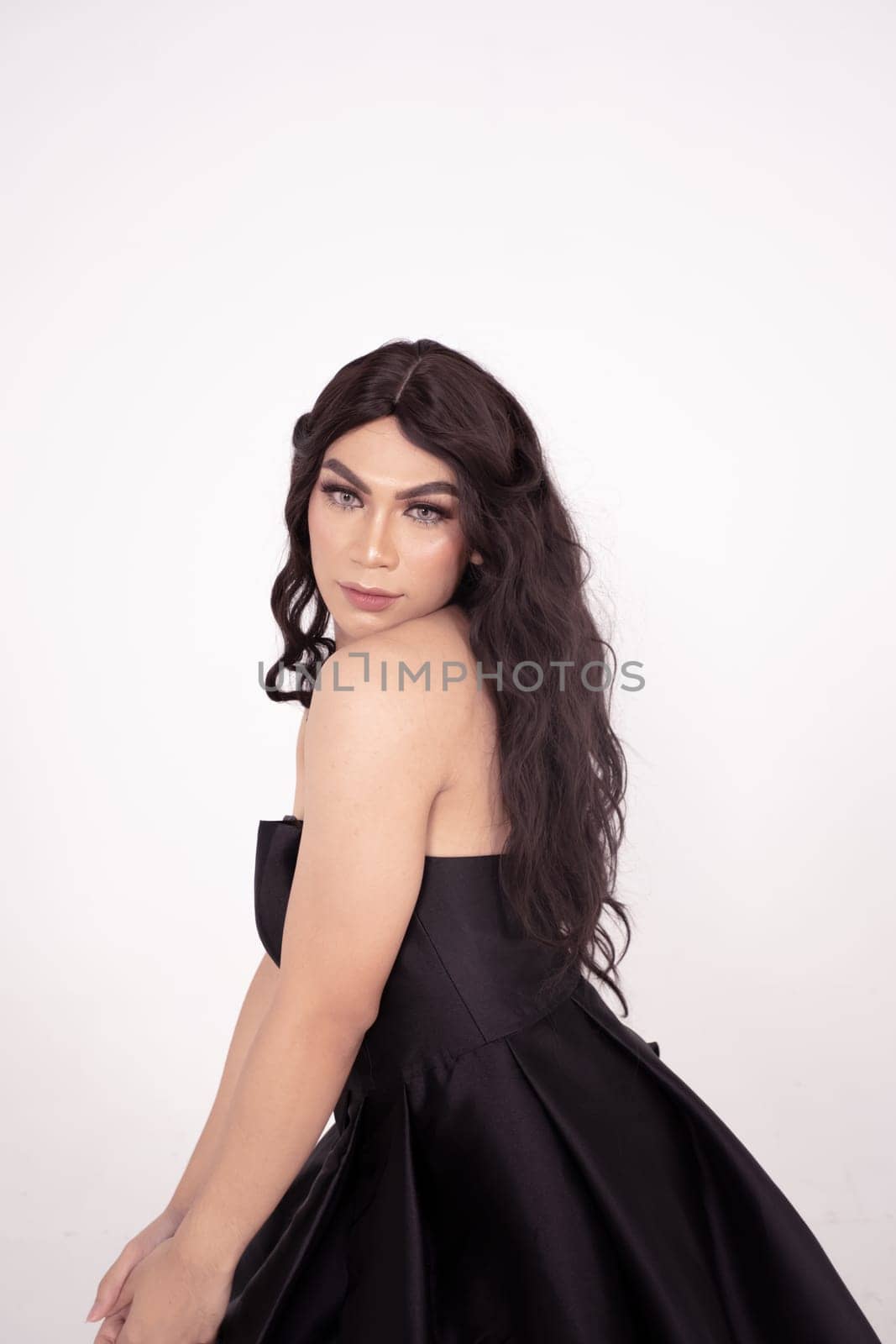 The wedding bride in black dress poses before the wedding ceremony in a white room