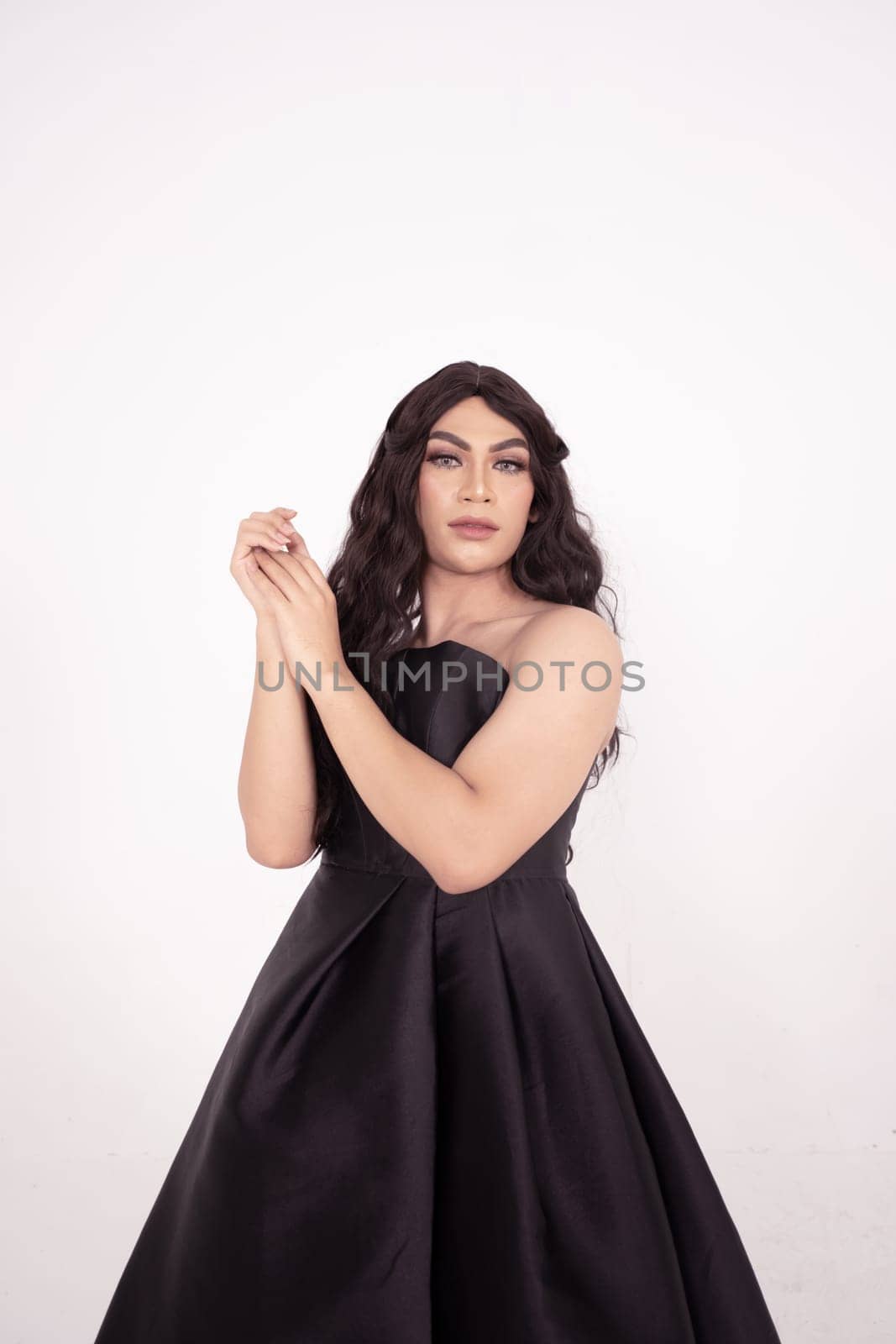 The wedding bride in black dress poses before the wedding ceremony in a white room