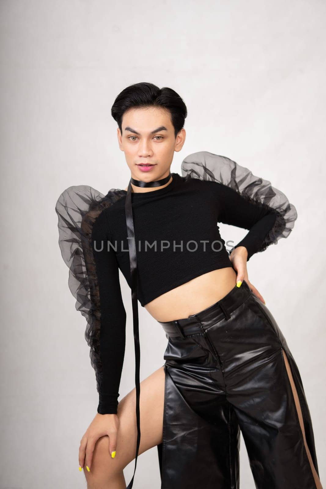 The beautiful man had style in a black costume with black hair and a pretty face inside the white studio