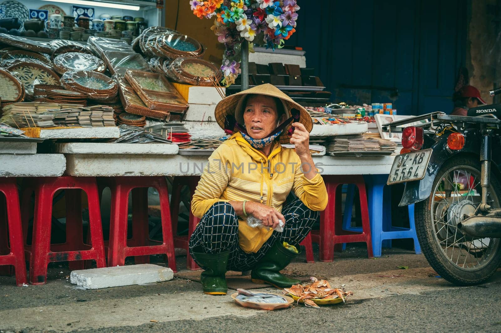 Vietnamese woman sells seafood at an Asian street market in Hoi An in Vietnam in Asia. Hoi An, Vietnam - December 2, 2024