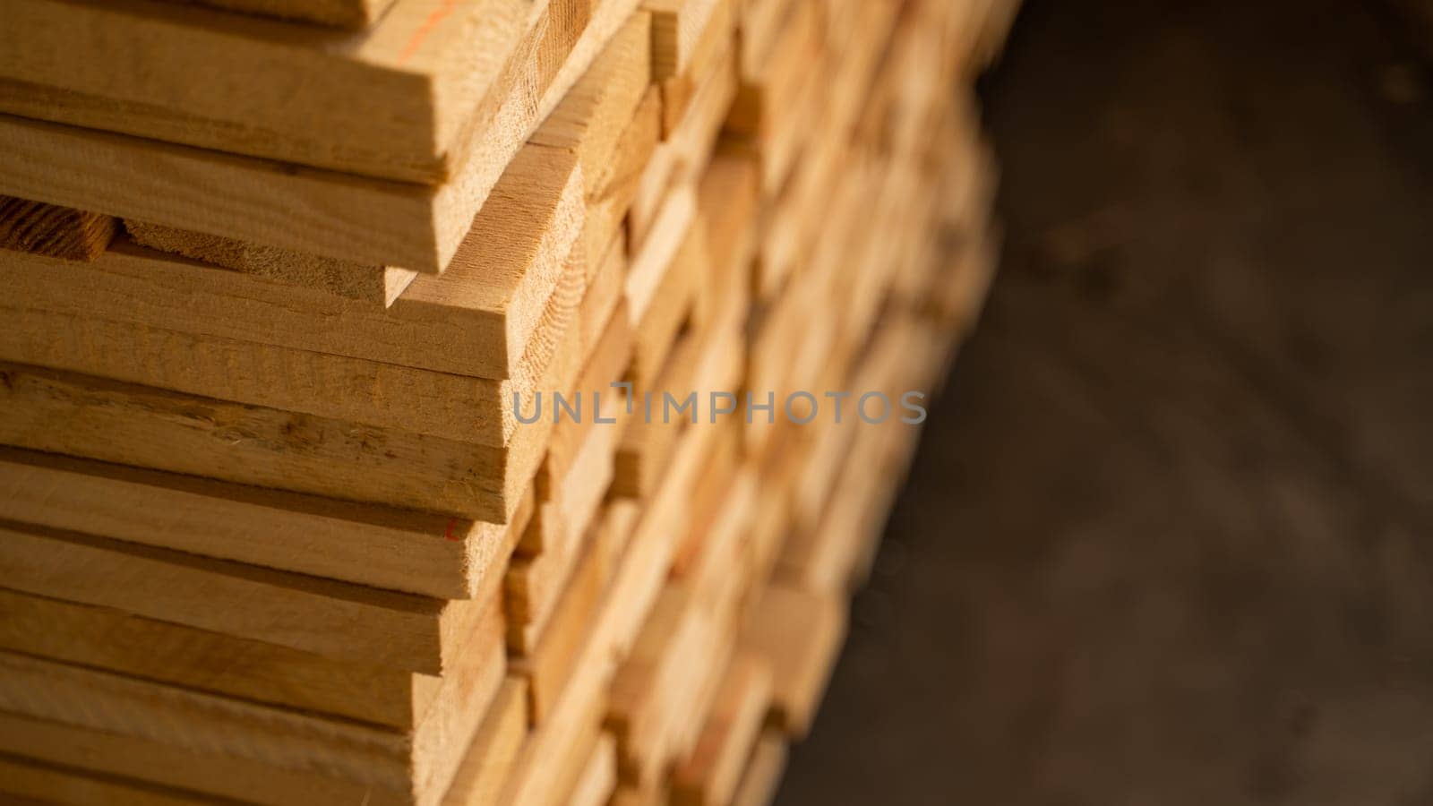 Warm-toned wooden planks stacked in depth, slightly blurred toward the rear. The focus and softness create an appealing material or industrial texture image.