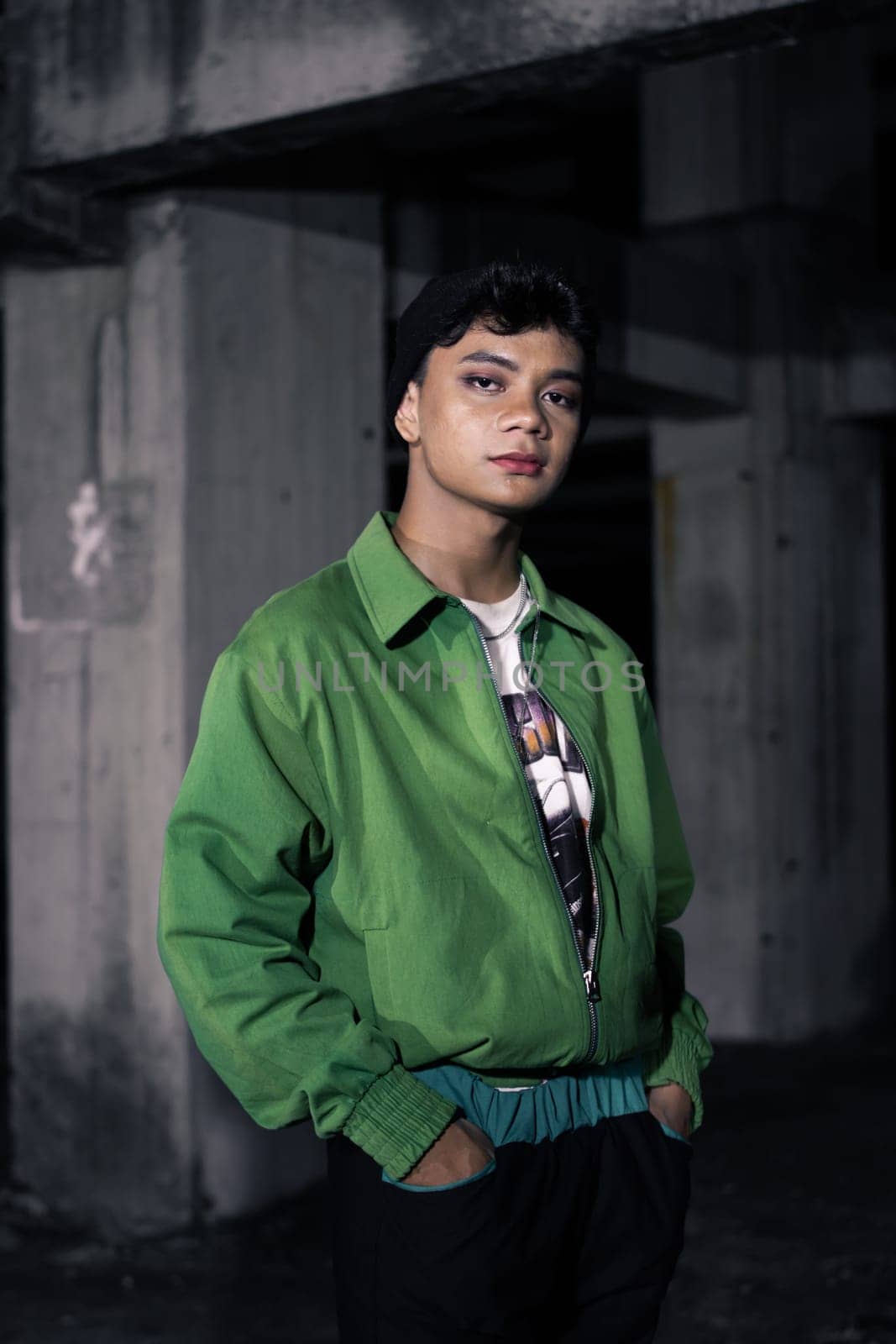 an Asian man is standing in an abandoned building in an eccentric outfit at night