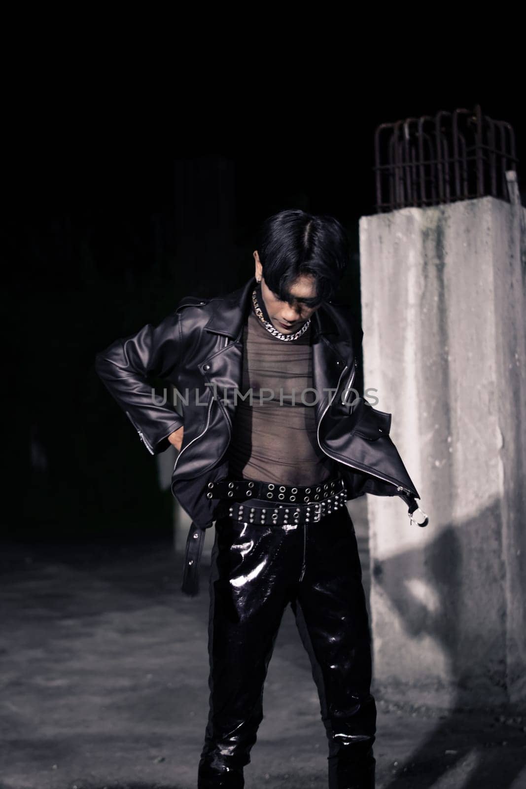 an asian man in a black leather jacket posing like a motorcycle gang in an old building