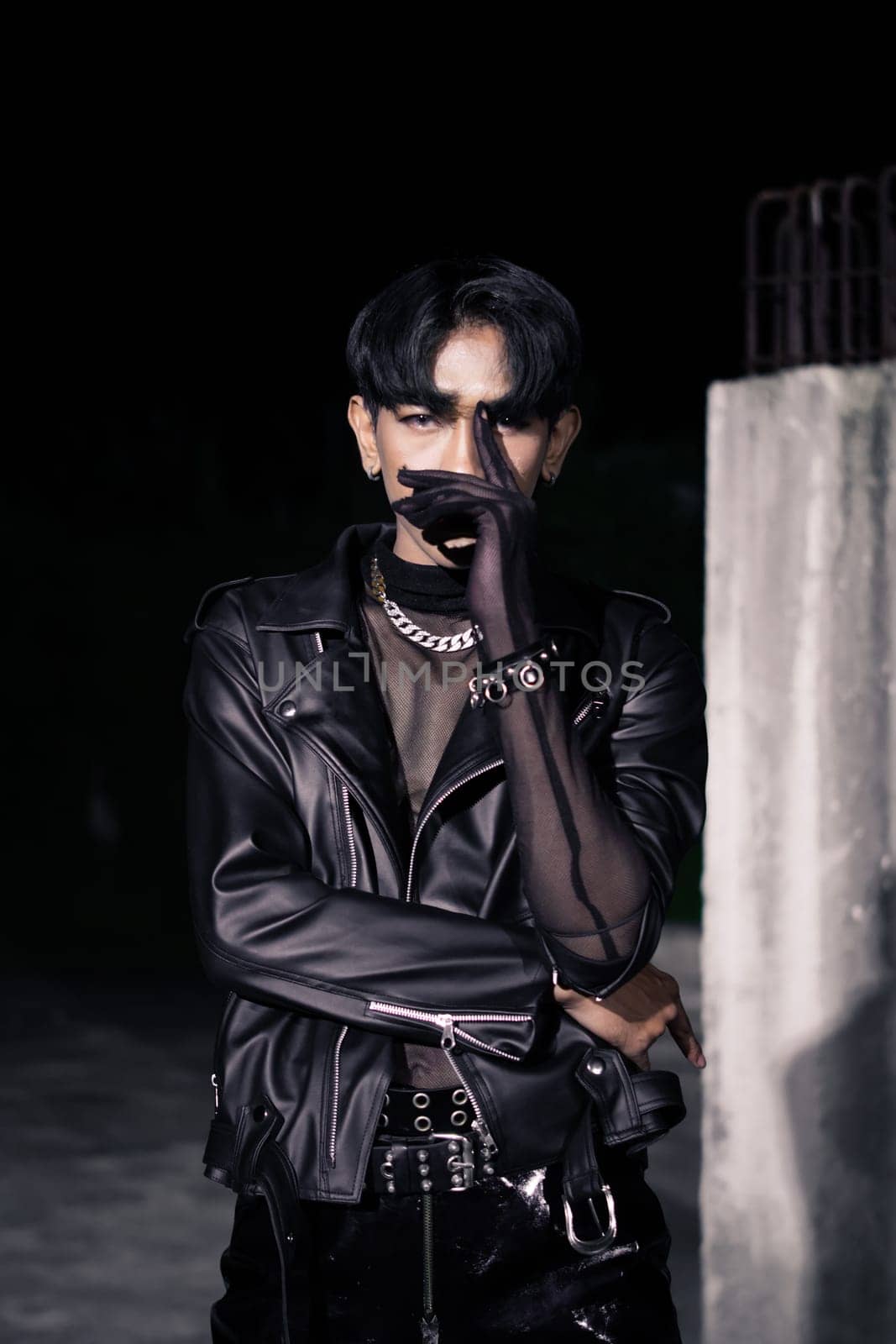 an asian man in a black leather jacket posing like a motorcycle gang in an old building