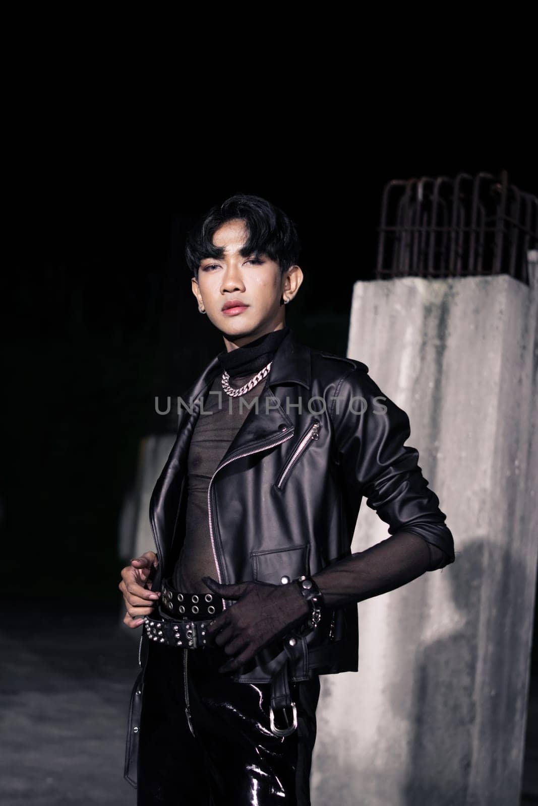 an asian man in a black leather jacket posing like a motorcycle gang in an old building