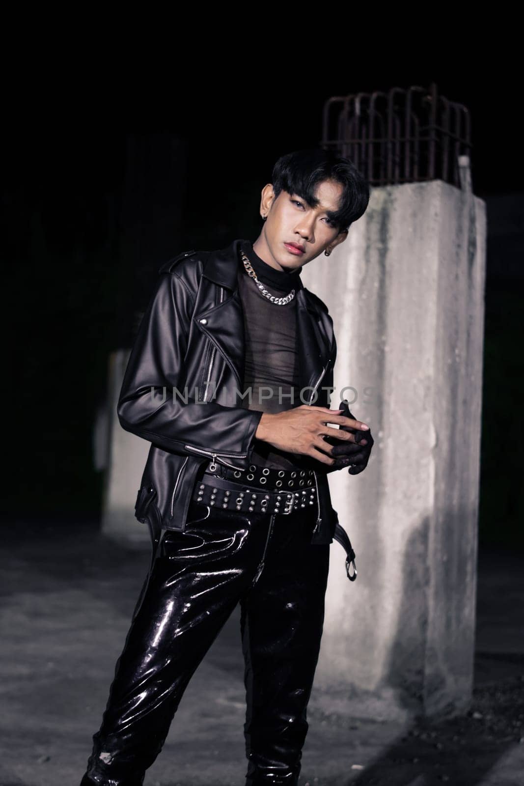 an asian man in a black leather jacket posing like a motorcycle gang in an old building