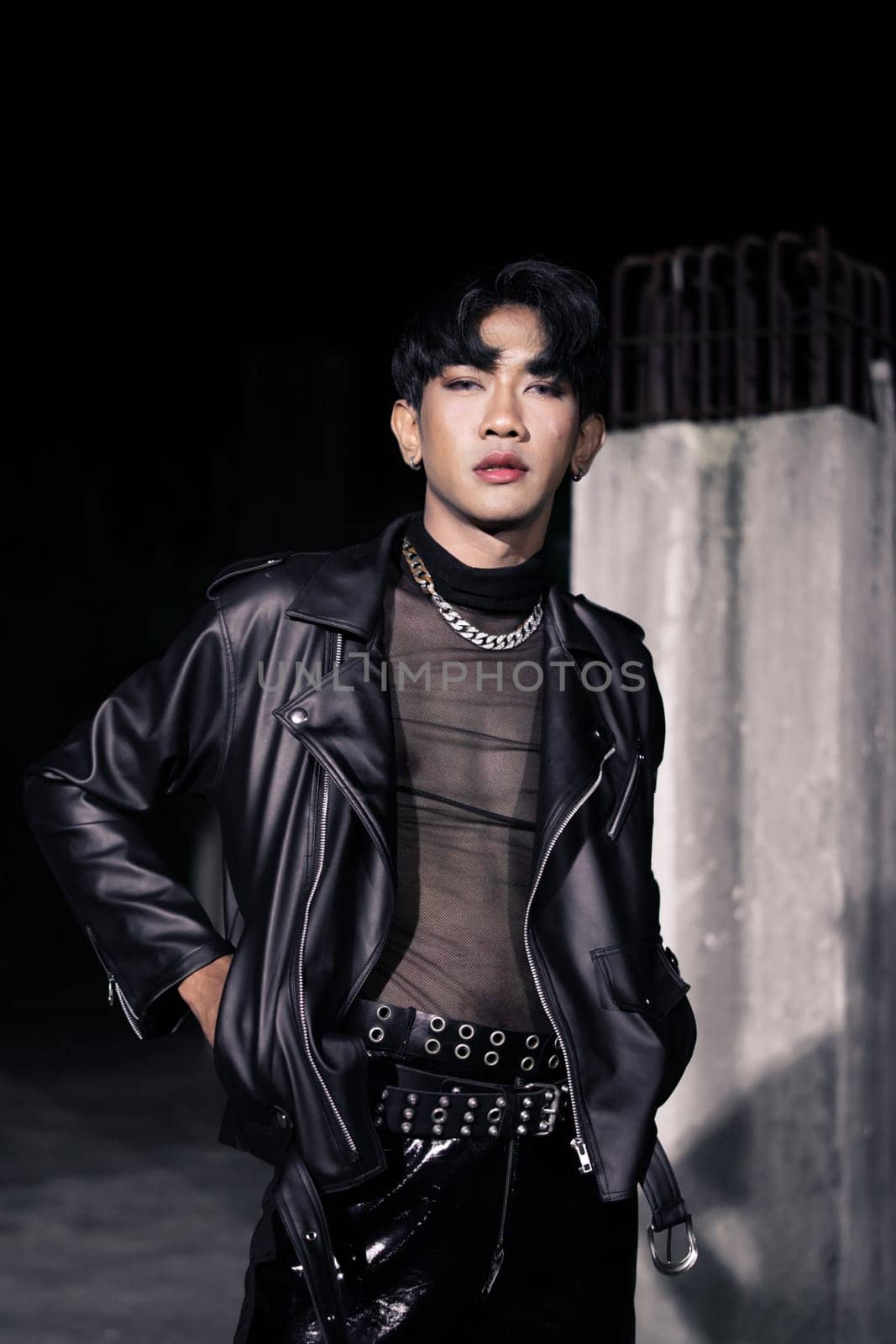 an asian man in a black leather jacket posing like a motorcycle gang in an old building
