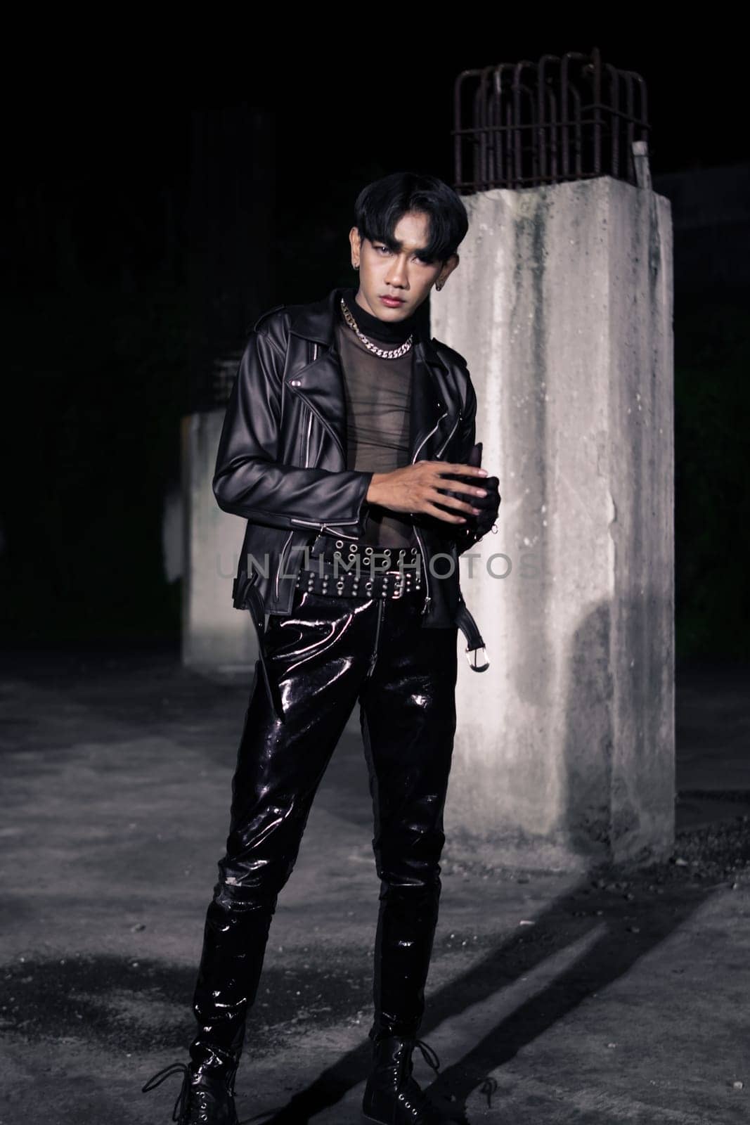 an asian man in a black leather jacket posing like a motorcycle gang in an old building