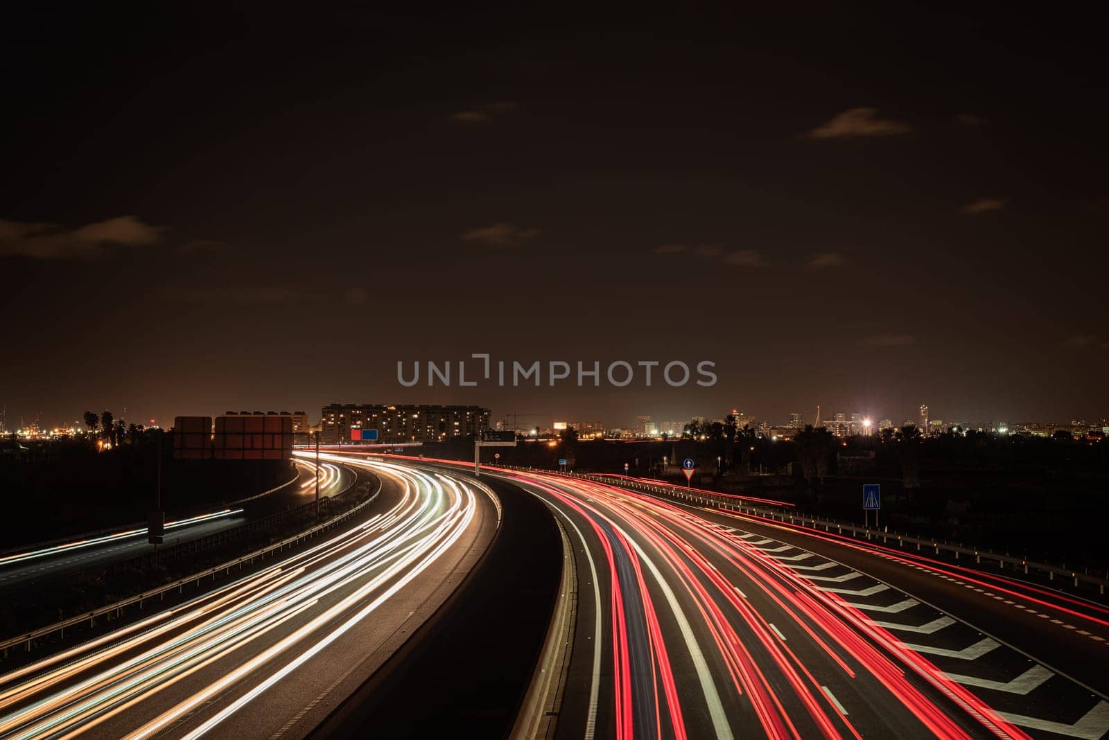 Long exposure photograph of car light trails. Car light trails on a highway entering and exiting a major city, Valencia